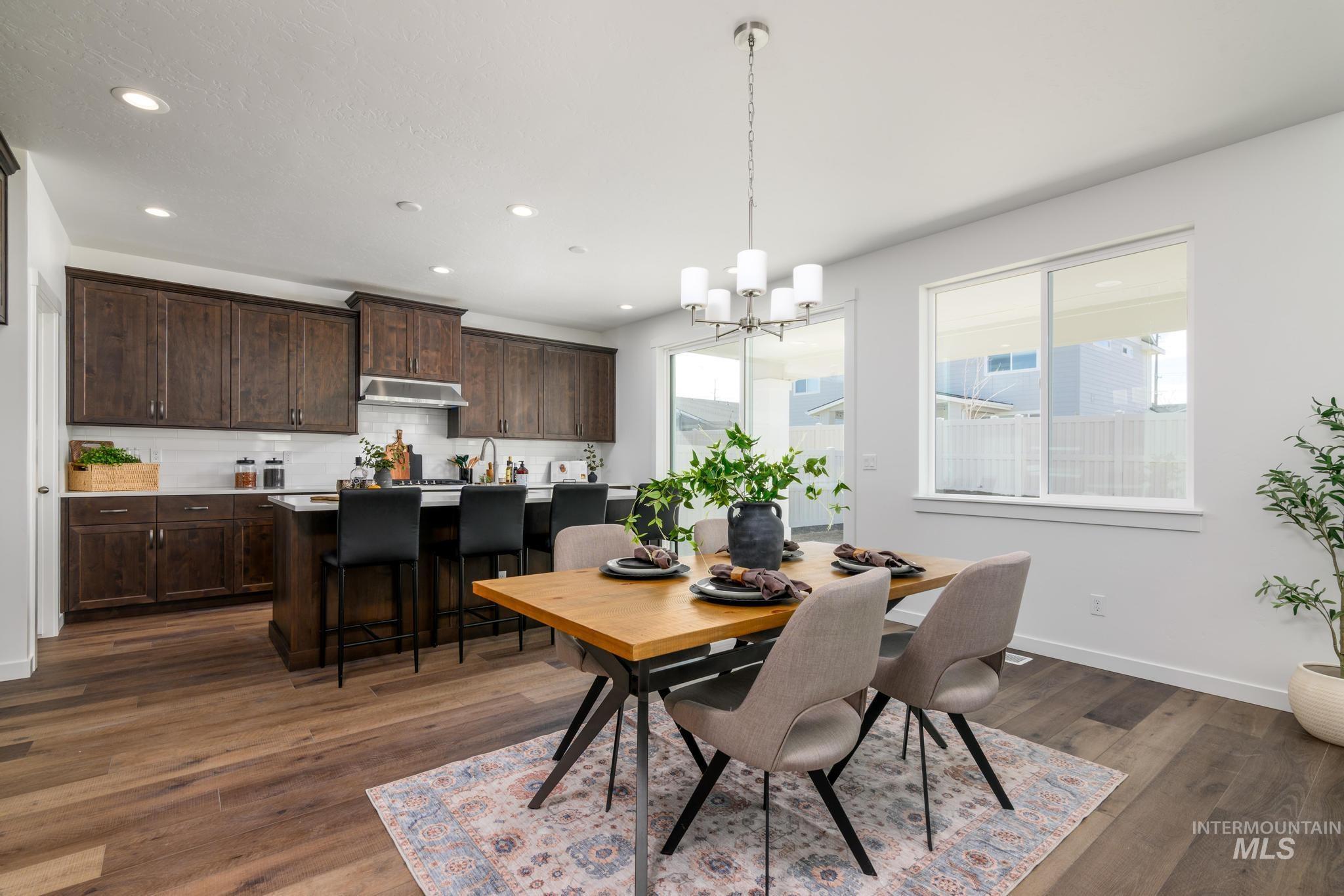 Dining area with recessed lighting, dark wood-style floors, and a chandelier