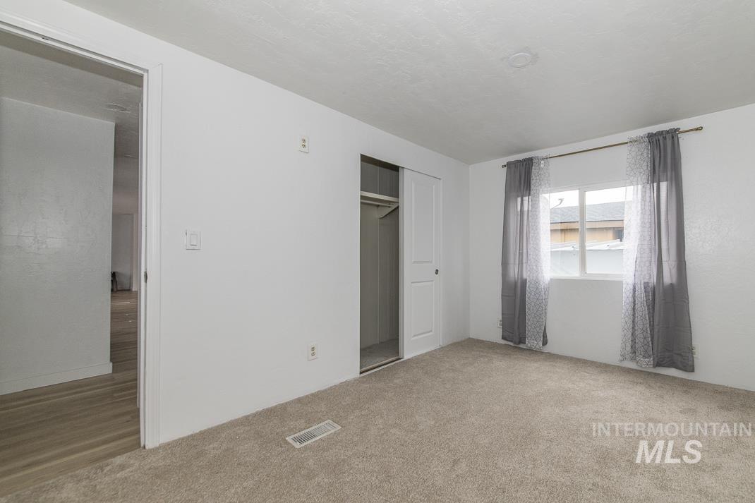 Unfurnished bedroom with a closet and light colored carpet