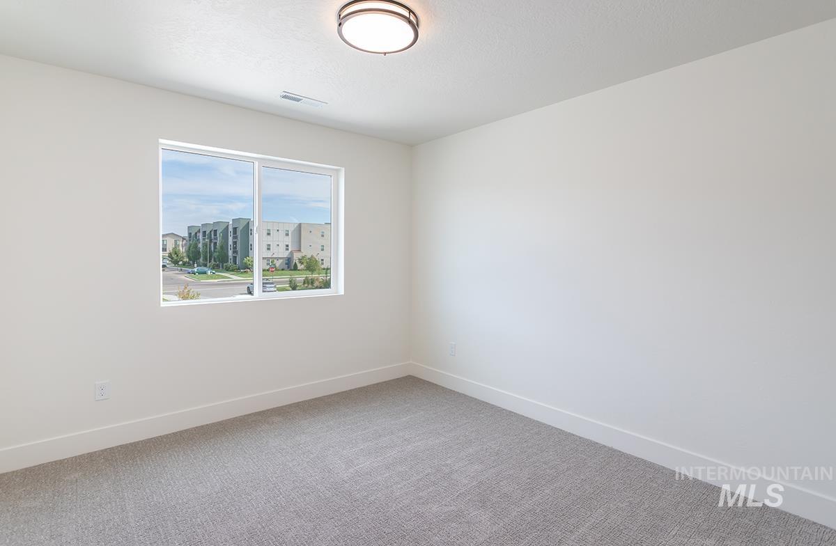 Carpeted empty room with baseboards and a textured ceiling