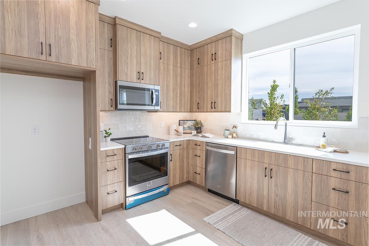 Kitchen featuring stainless steel appliances, light wood finished floors, decorative backsplash, recessed lighting, and light stone counters