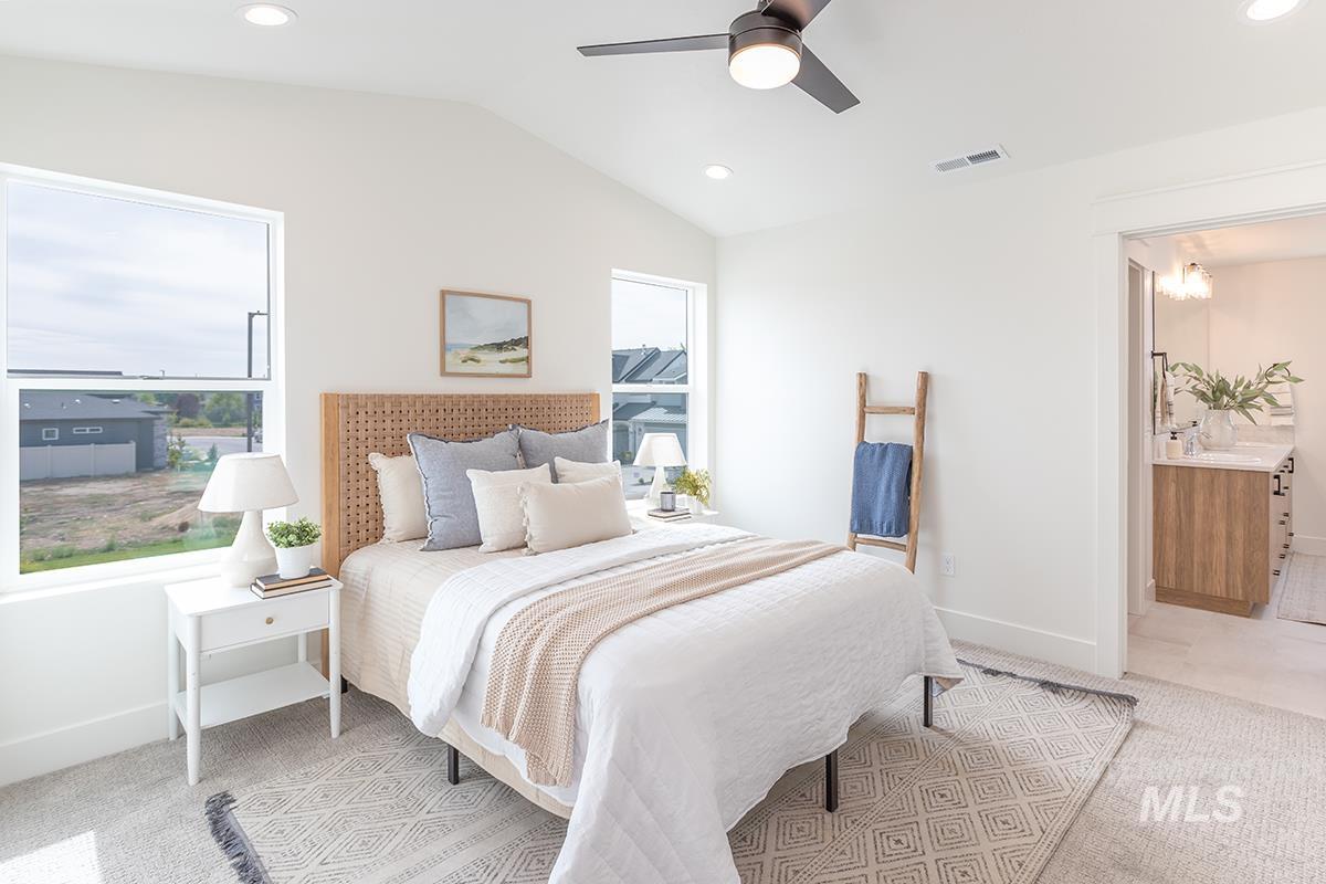 Bedroom with vaulted ceiling, recessed lighting, light colored carpet, a ceiling fan, and multiple windows