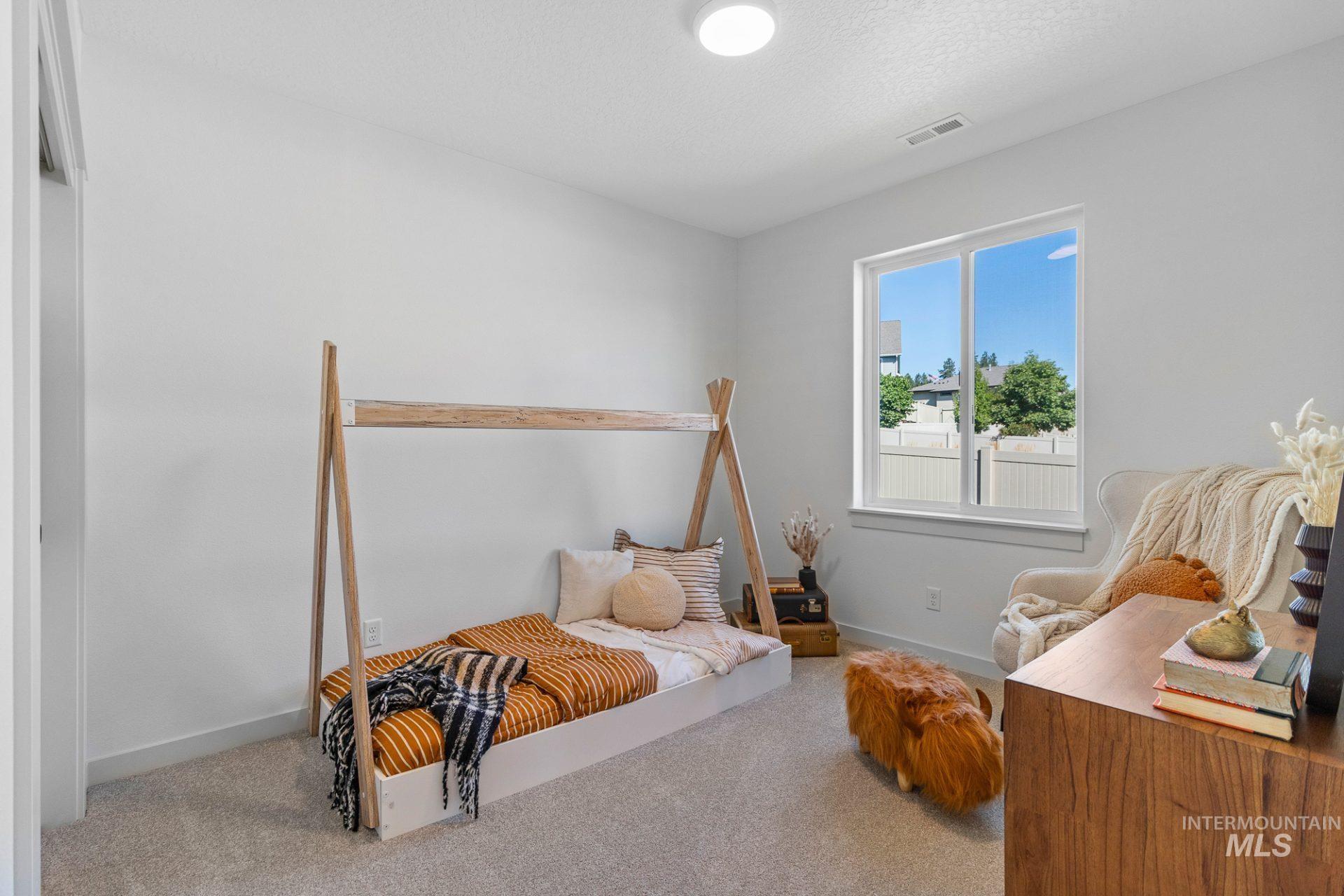 Carpeted bedroom with baseboards and a textured ceiling