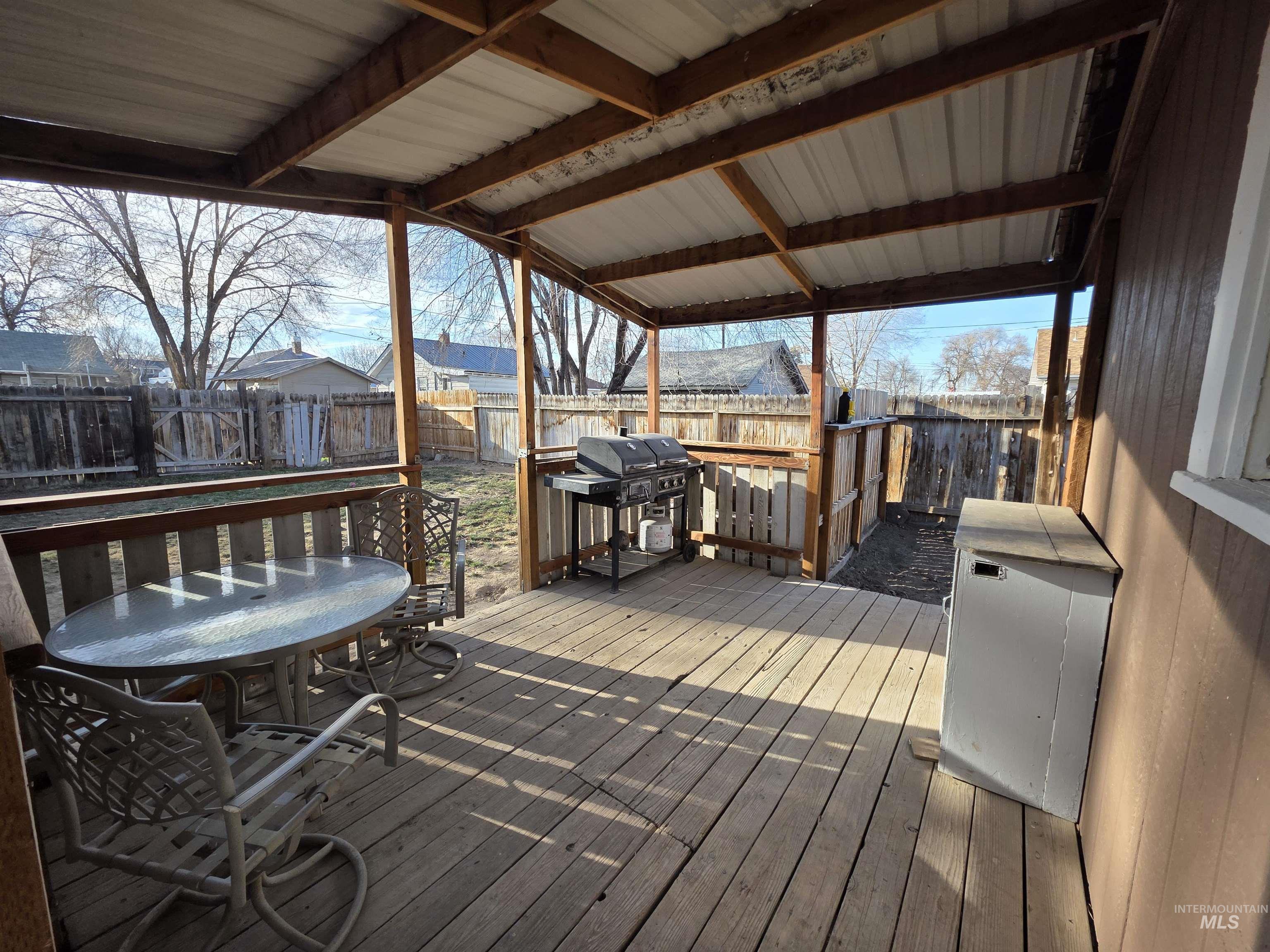 Wooden terrace featuring a fenced backyard and area for grilling