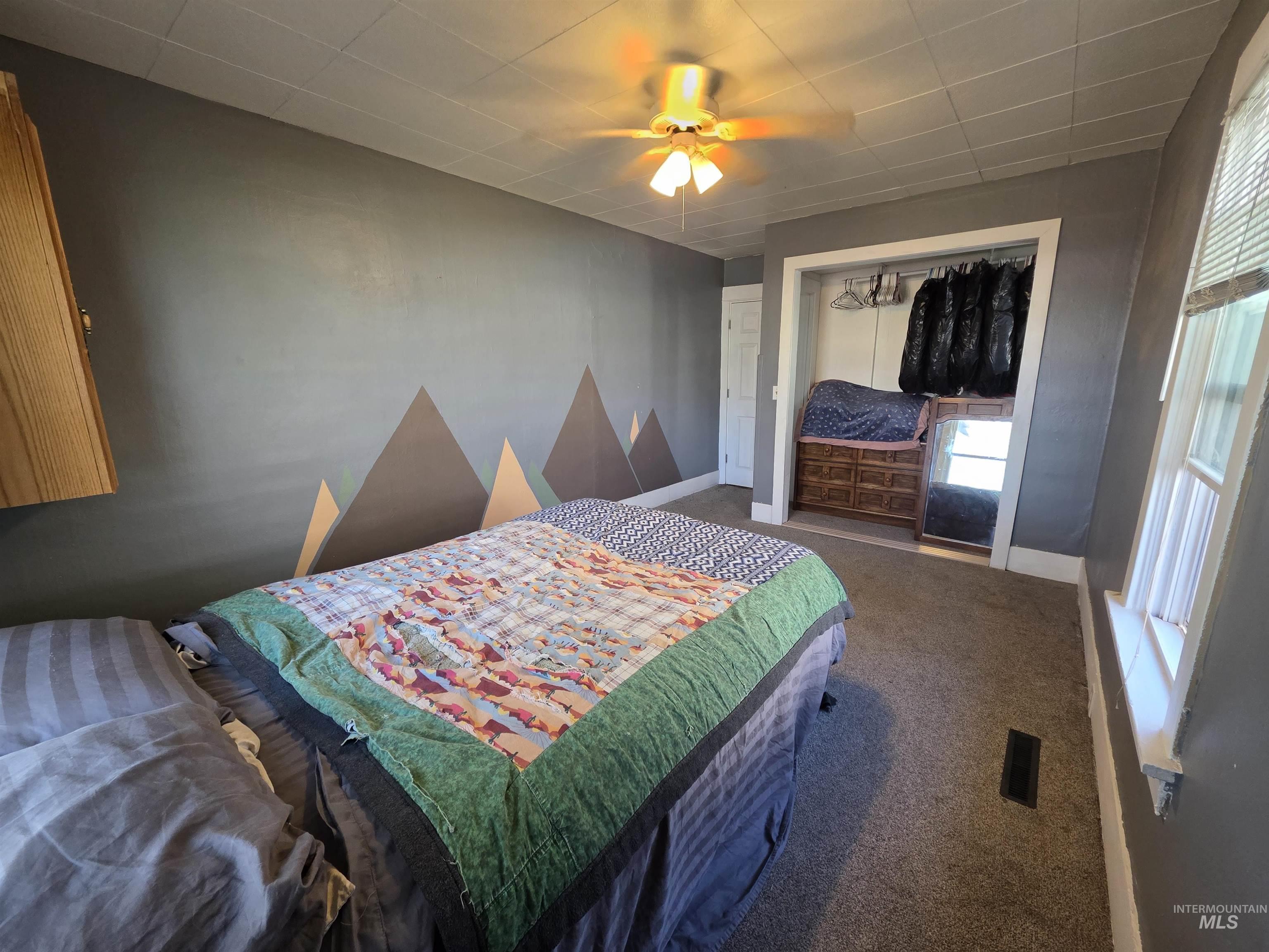 Bedroom with a closet, ceiling fan, and carpet