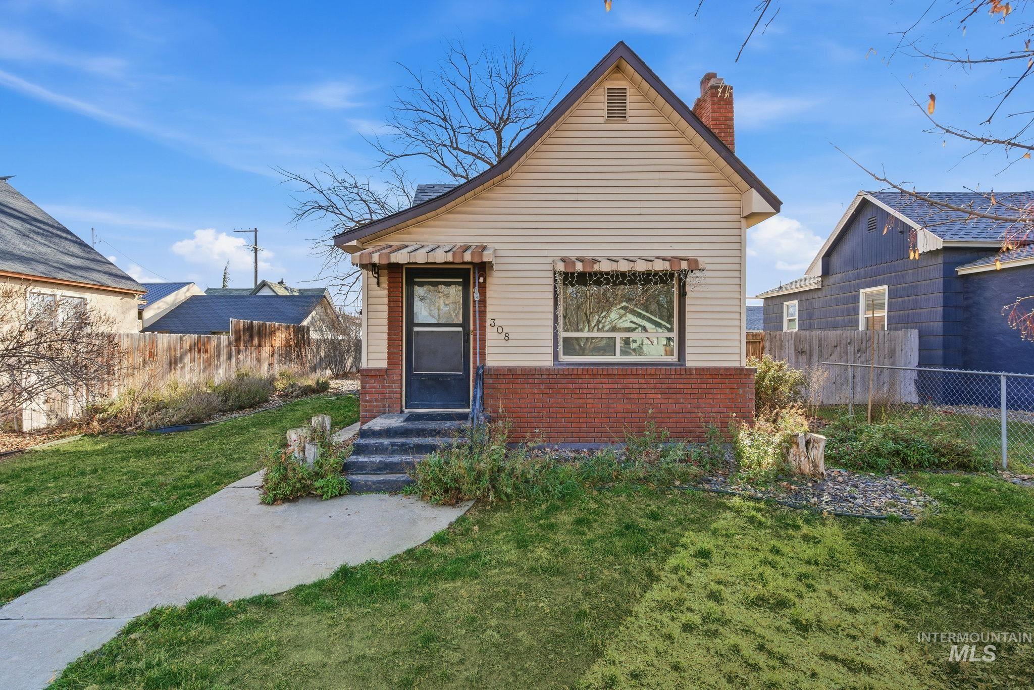 View of front of home with brick siding and a chimney