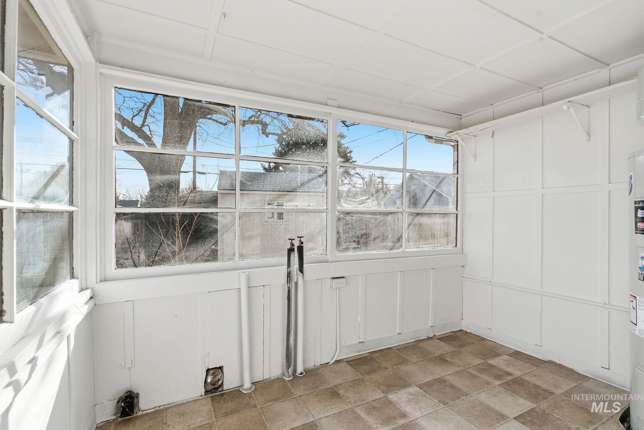 Unfurnished sunroom featuring electric water heater