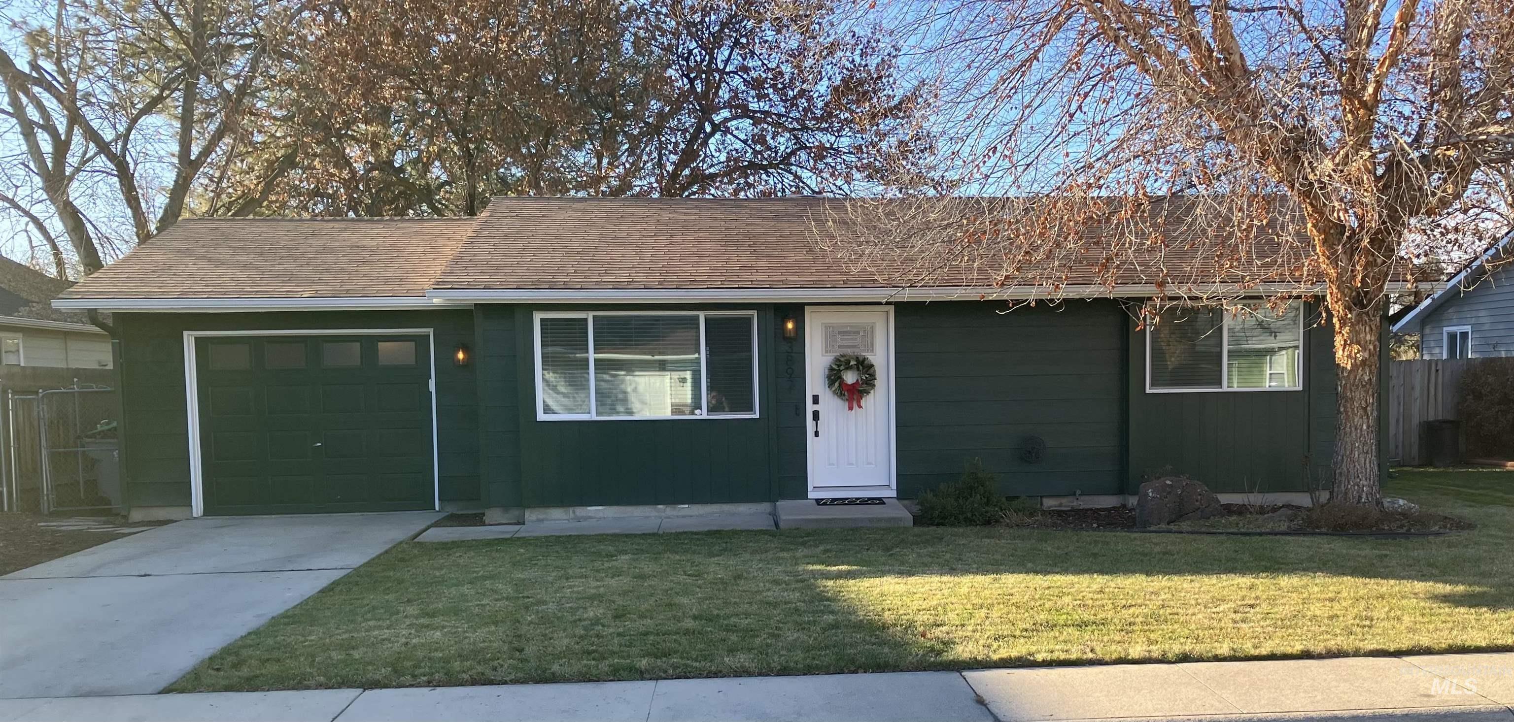 Ranch-style home with concrete driveway, an attached garage, and roof with shingles