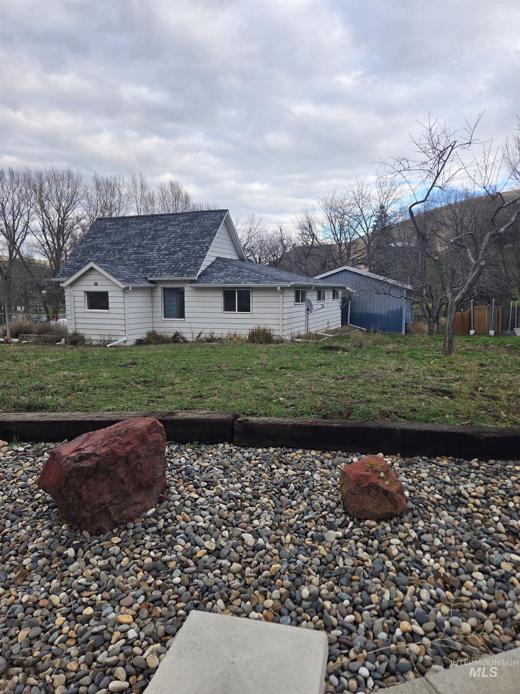 View of front of property with roof with shingles and a front lawn