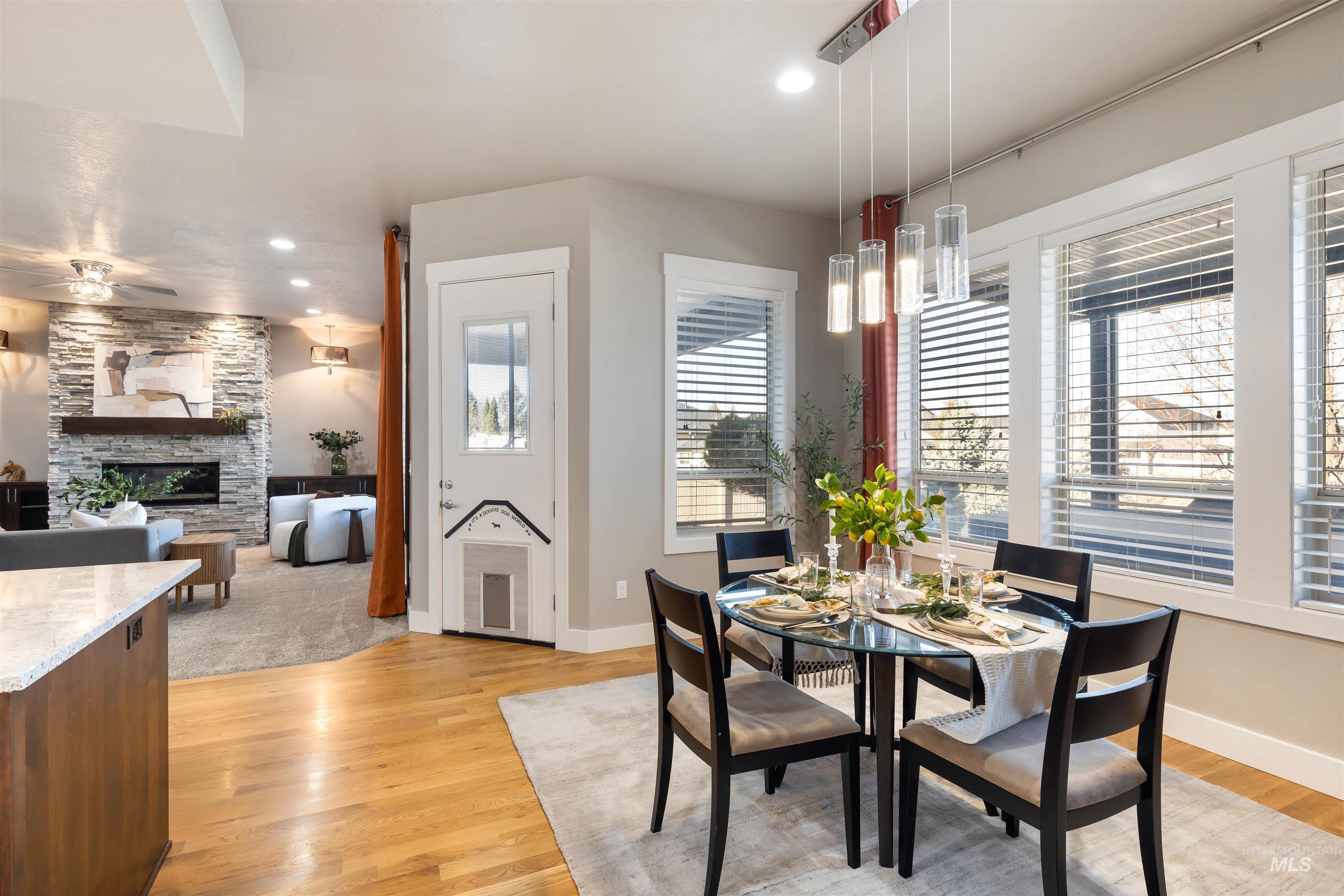 Dining room with a stone fireplace, recessed lighting, and light wood-type flooring