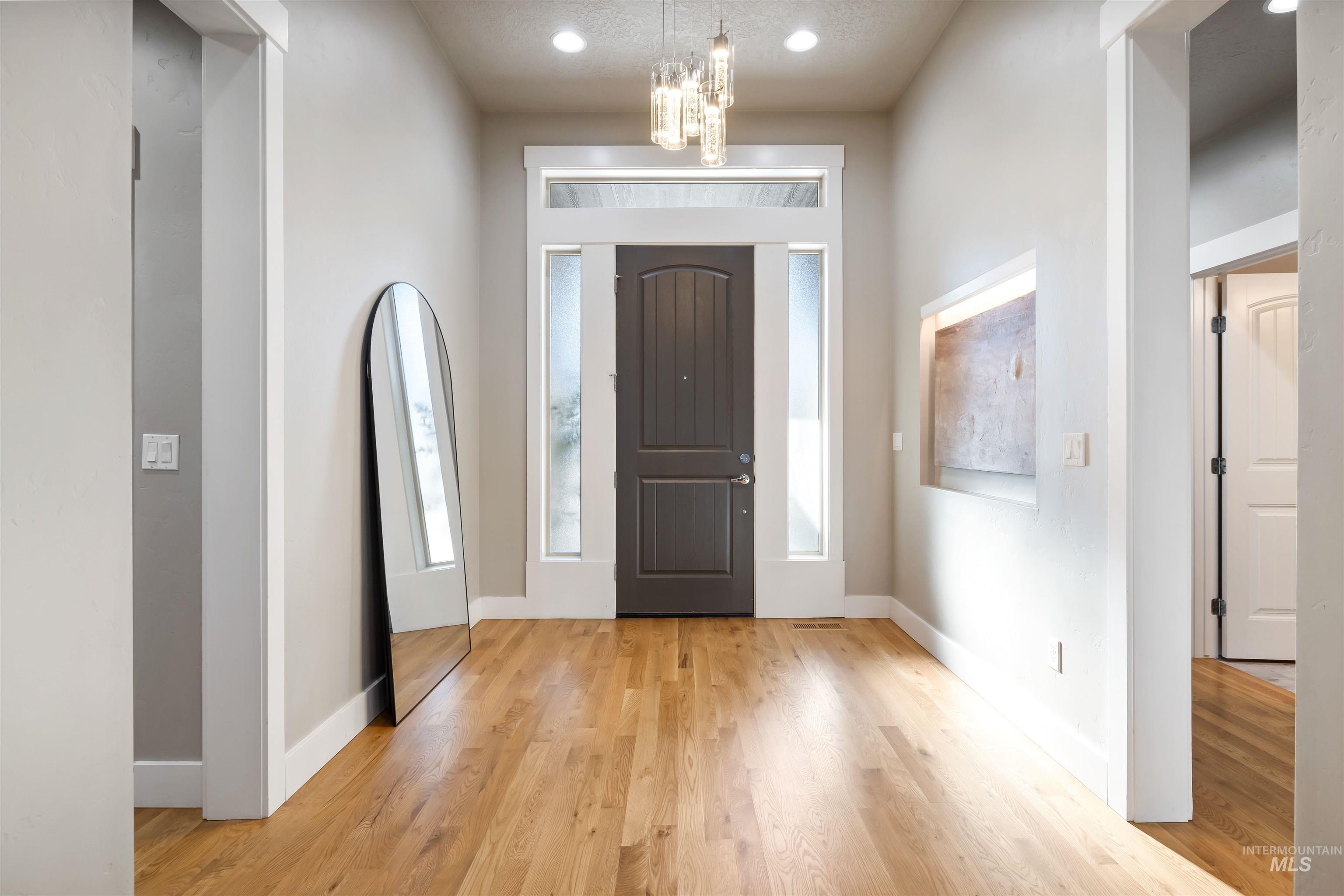 Foyer with a chandelier, recessed lighting, and light wood-type flooring