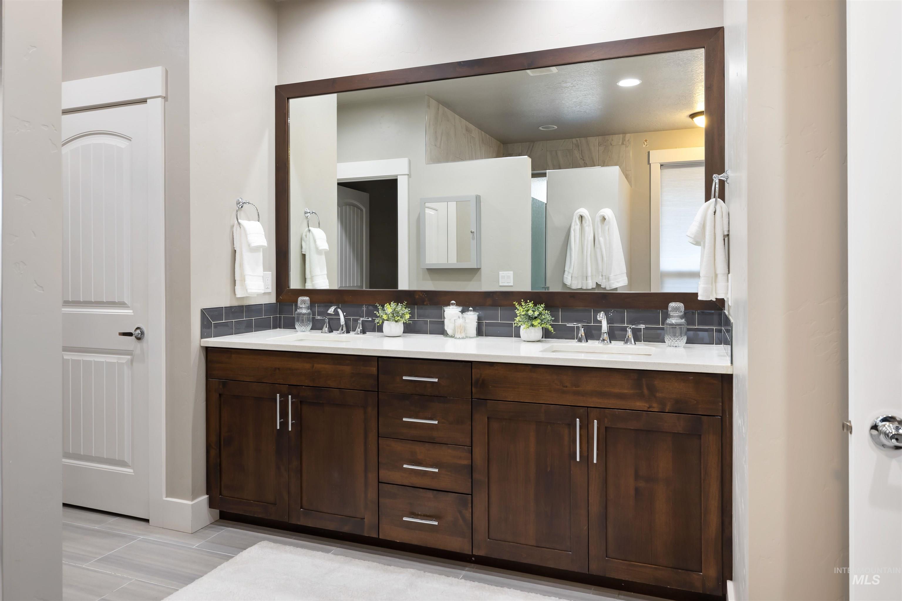 Full bathroom with double vanity and tasteful backsplash