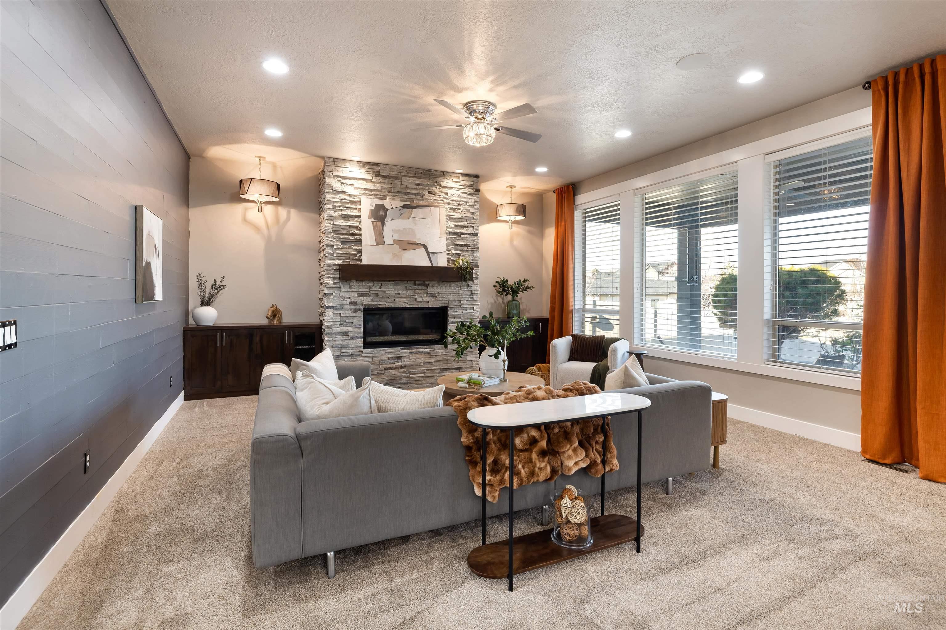 Living area with a textured ceiling, a fireplace, light carpet, recessed lighting, and ceiling fan