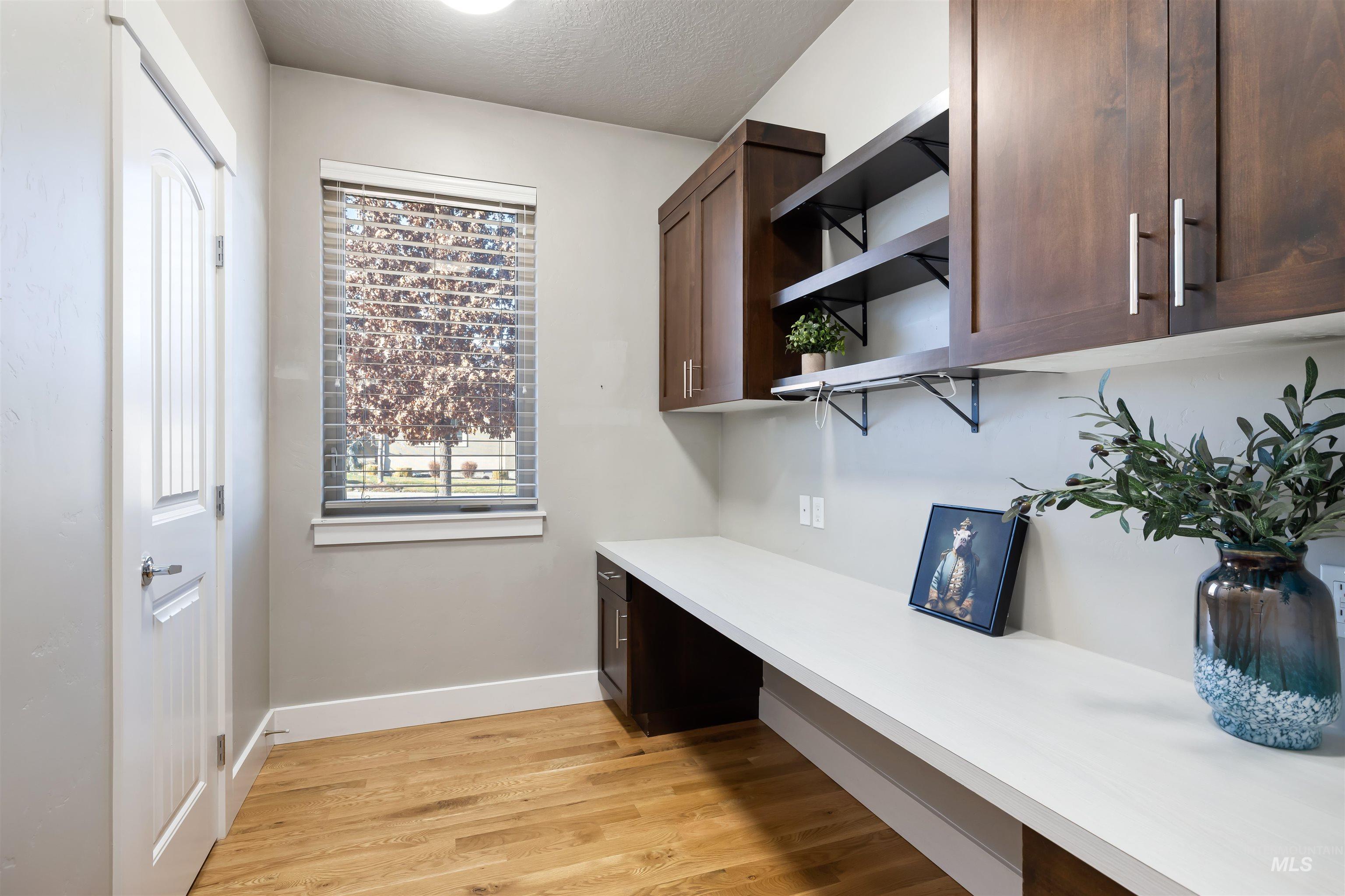 Office featuring light wood-style flooring and a textured ceiling