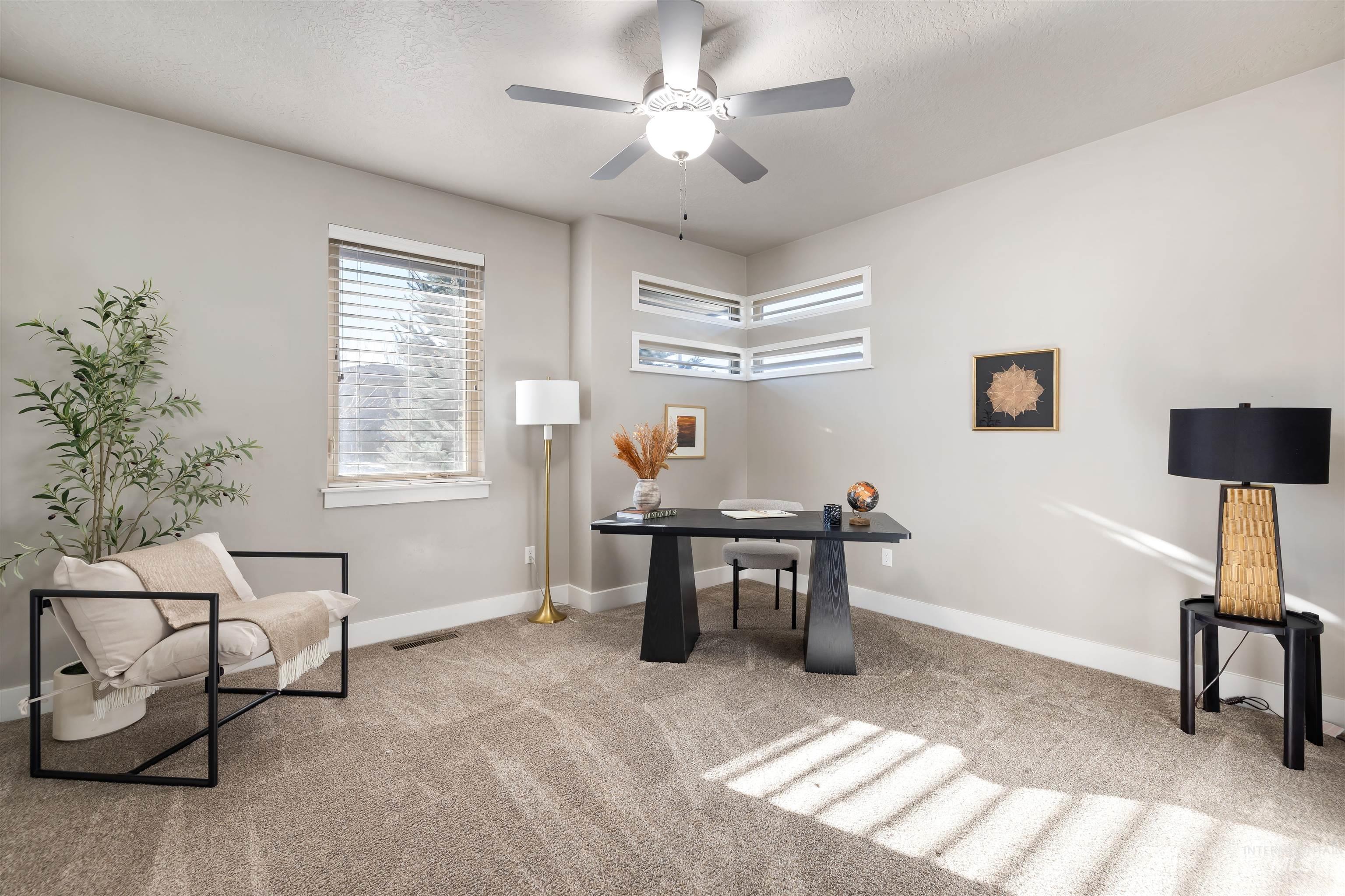 Carpeted office with a textured ceiling and a ceiling fan