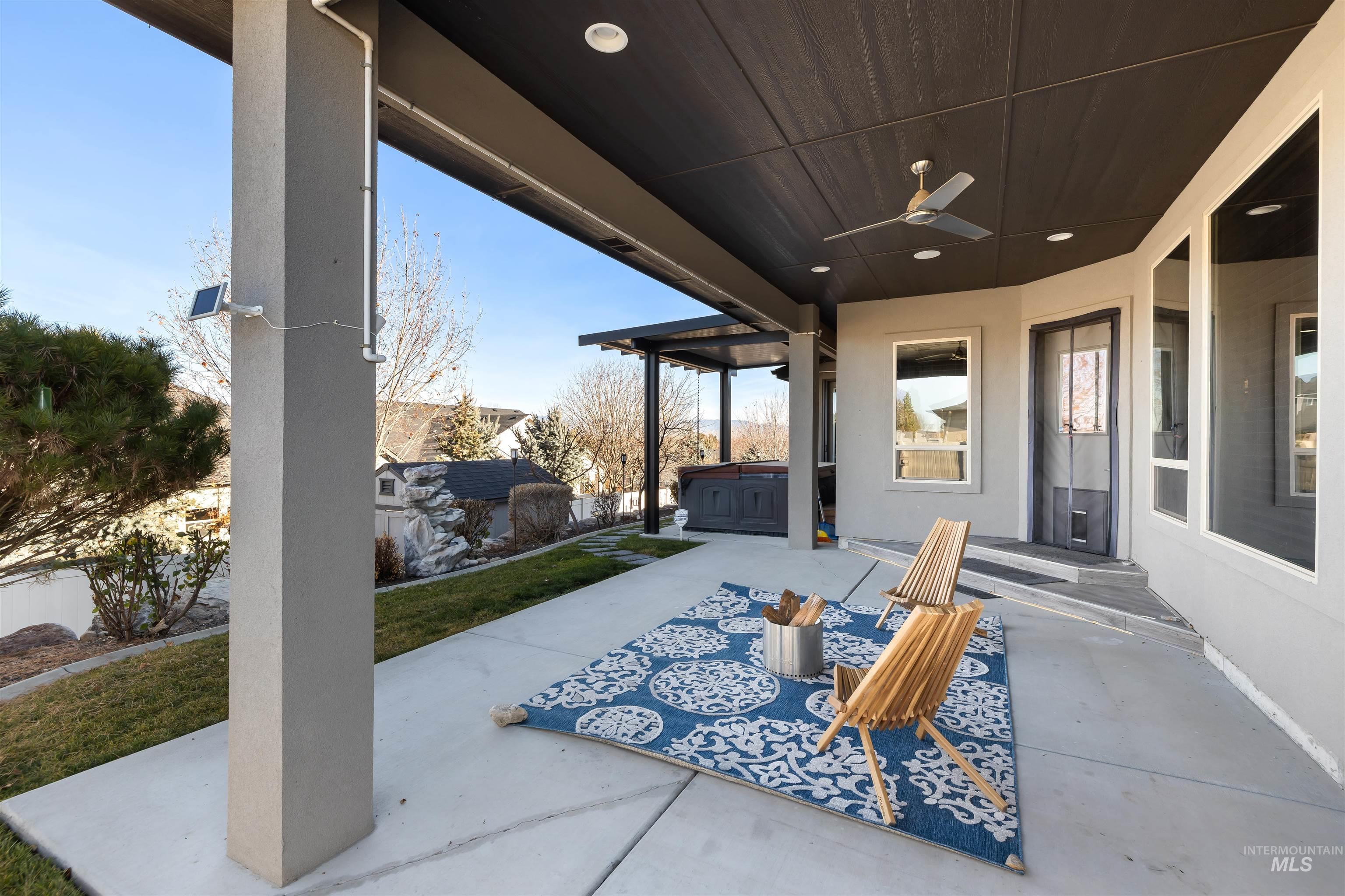 View of patio with a hot tub and a ceiling fan