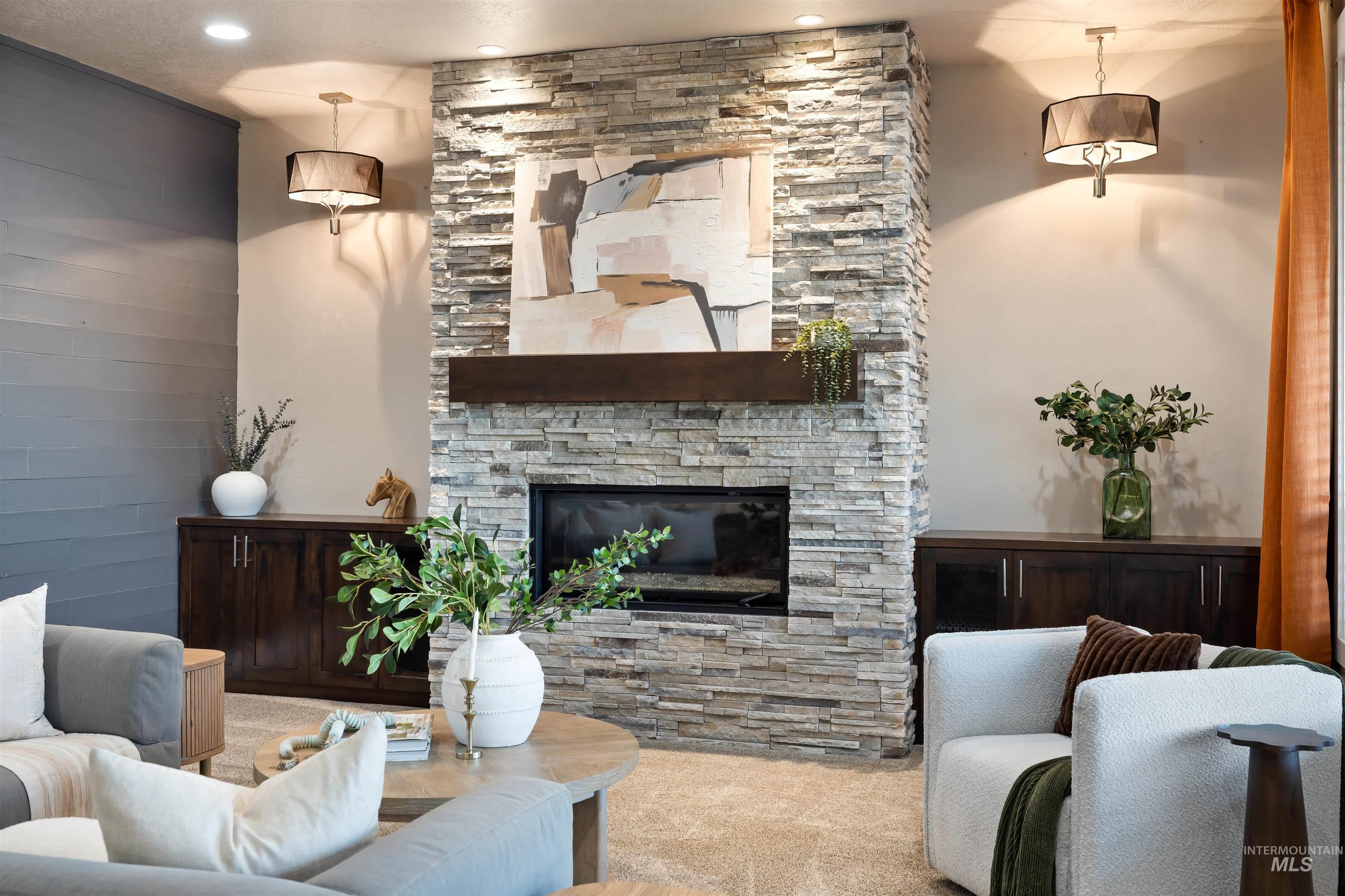 Living area featuring a stone fireplace, carpet, and recessed lighting