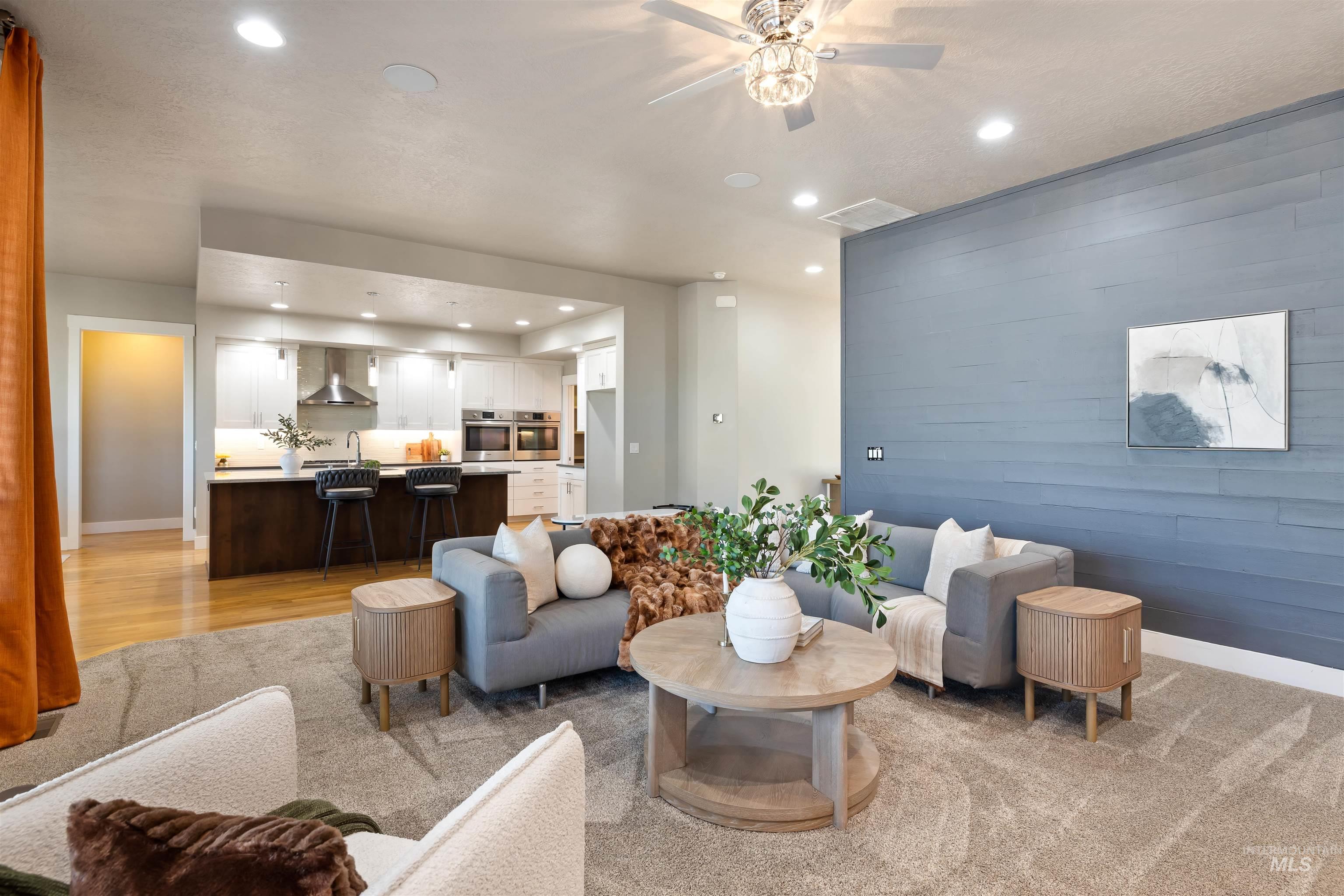Living area with an accent wall, recessed lighting, and wood walls