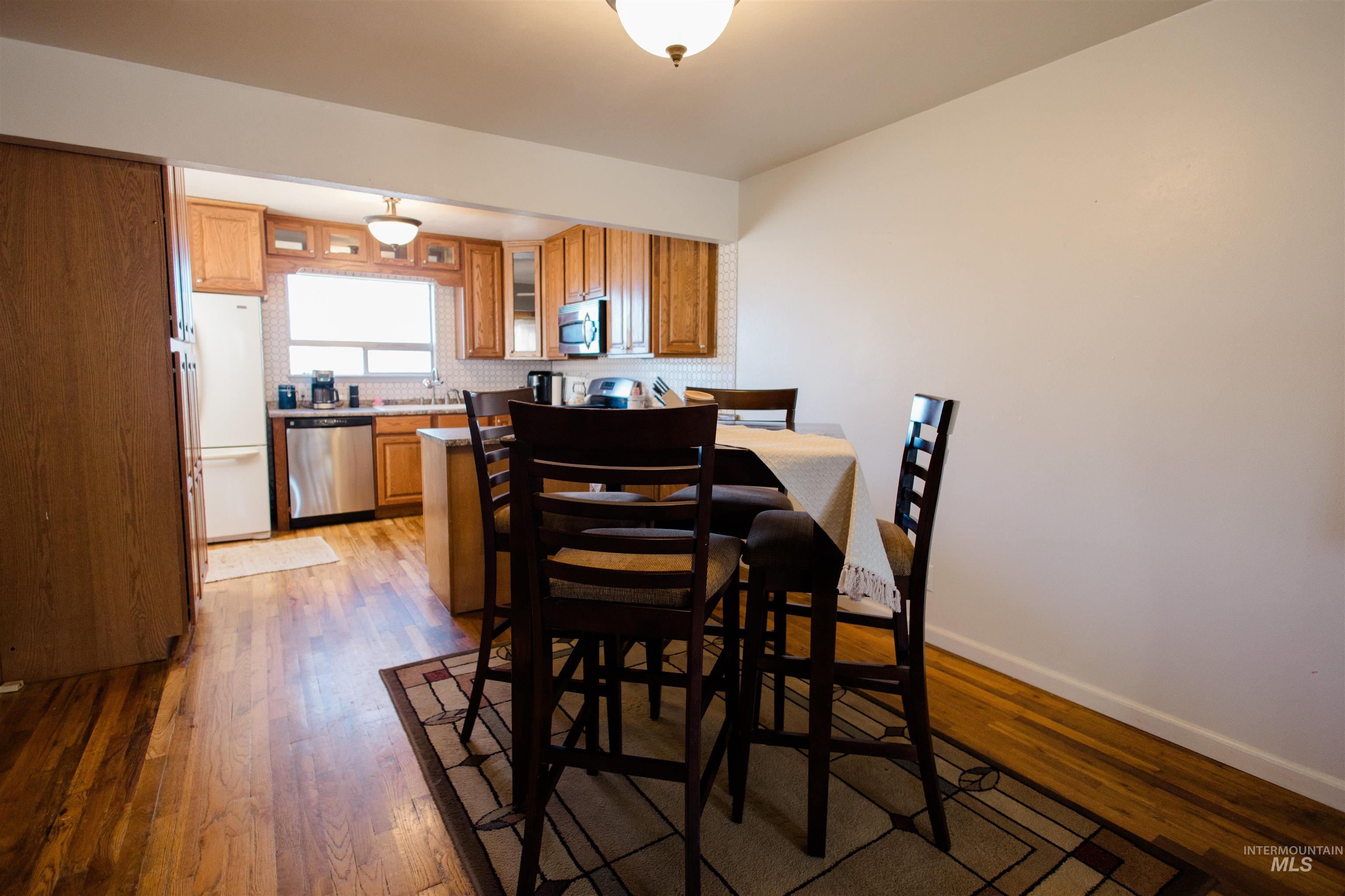 Dining space featuring dark wood finished floors and baseboards