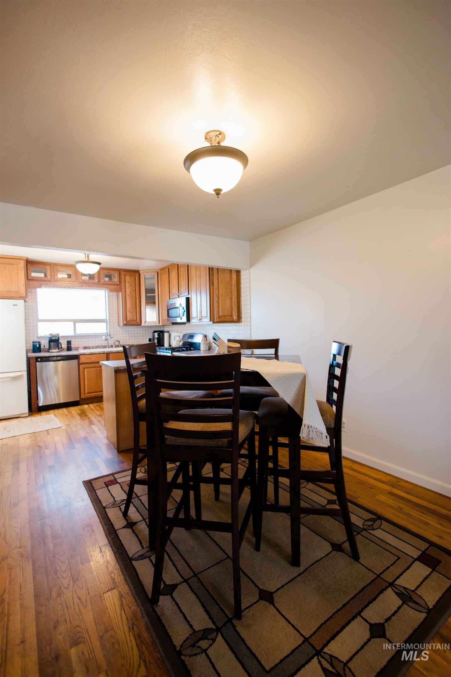 Dining area featuring dark wood-type flooring and baseboards