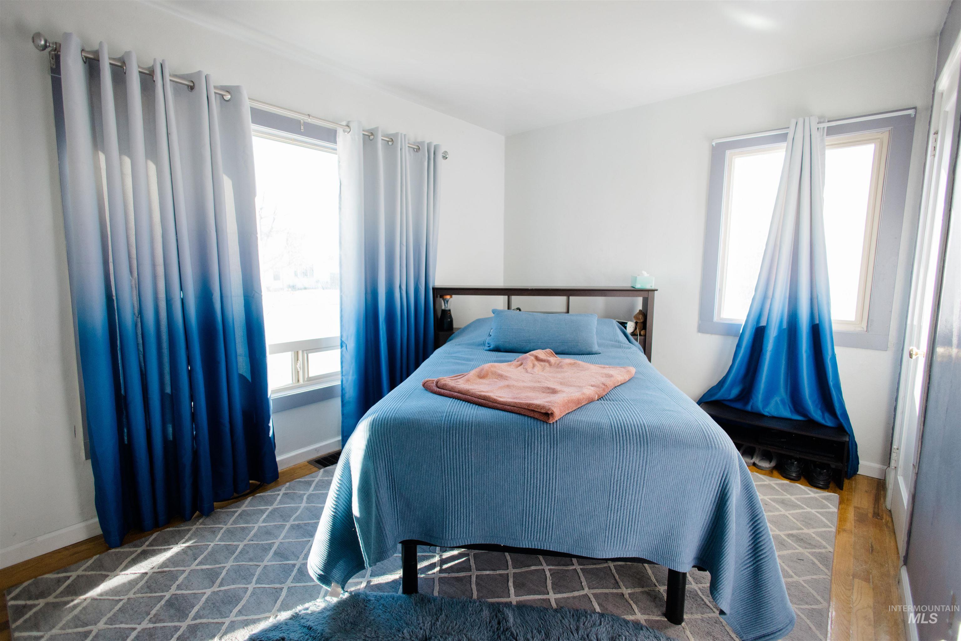 Bedroom featuring wood finished floors and multiple windows