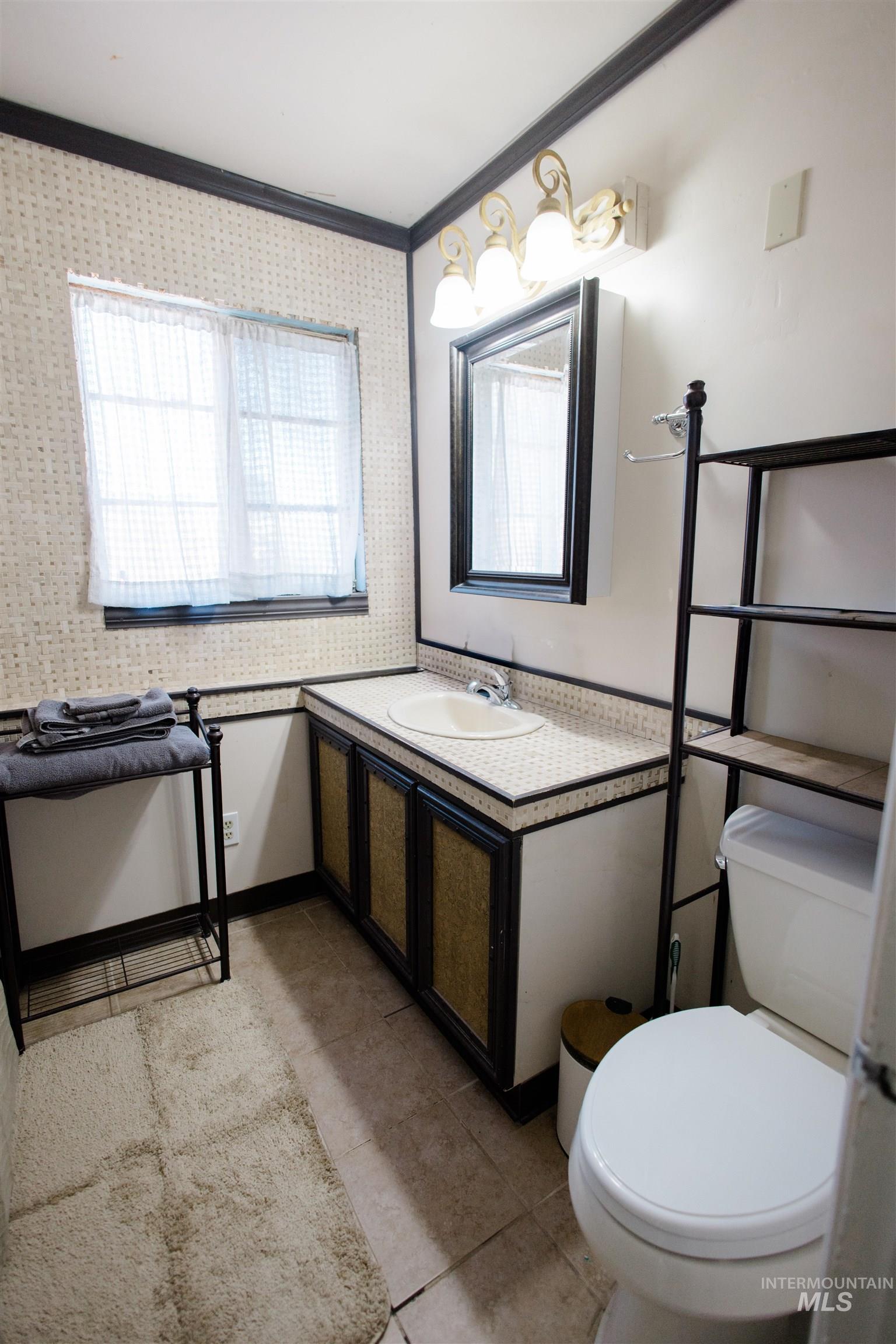 Half bath featuring vanity and ornamental molding