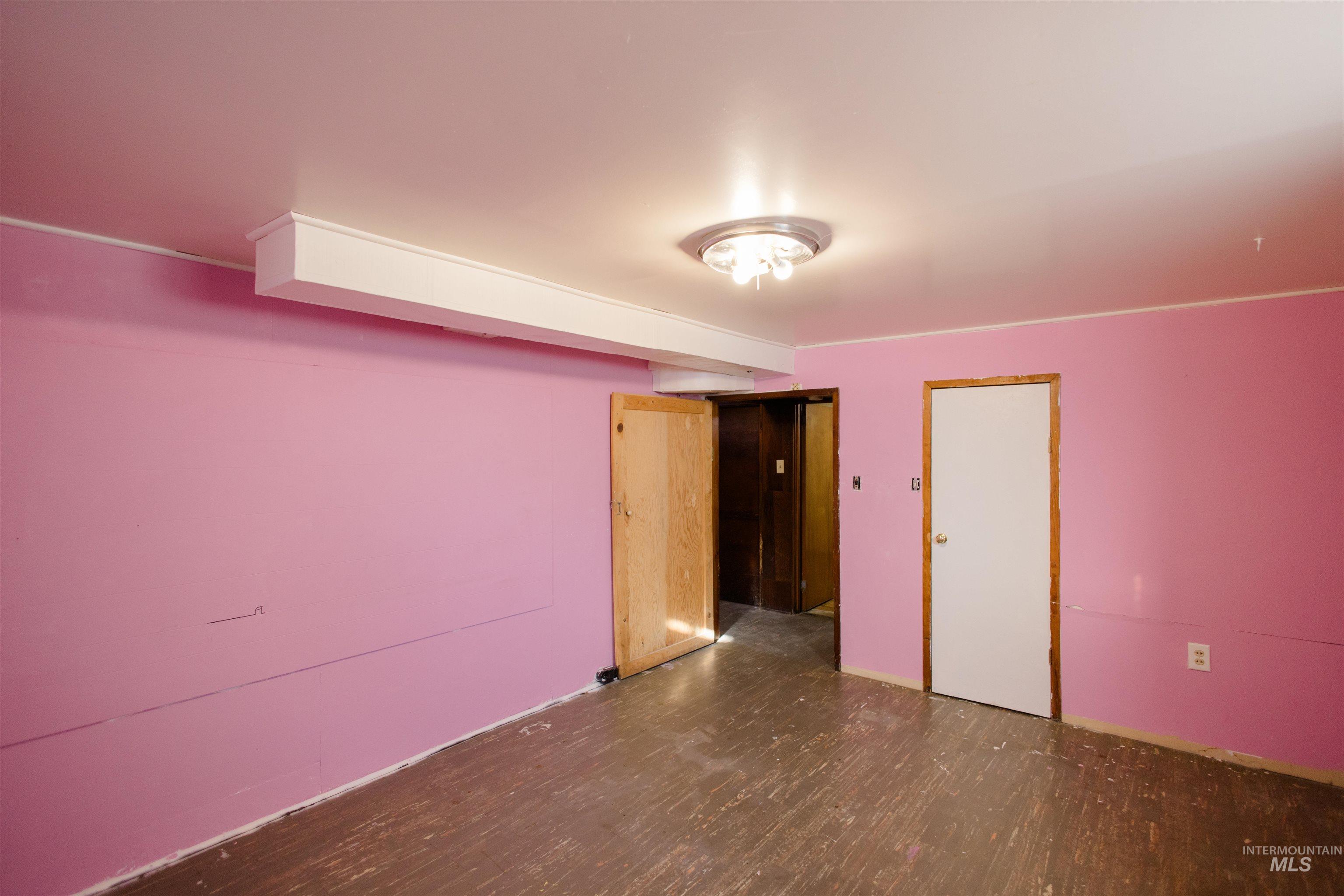 Unfurnished bedroom featuring dark wood-style floors