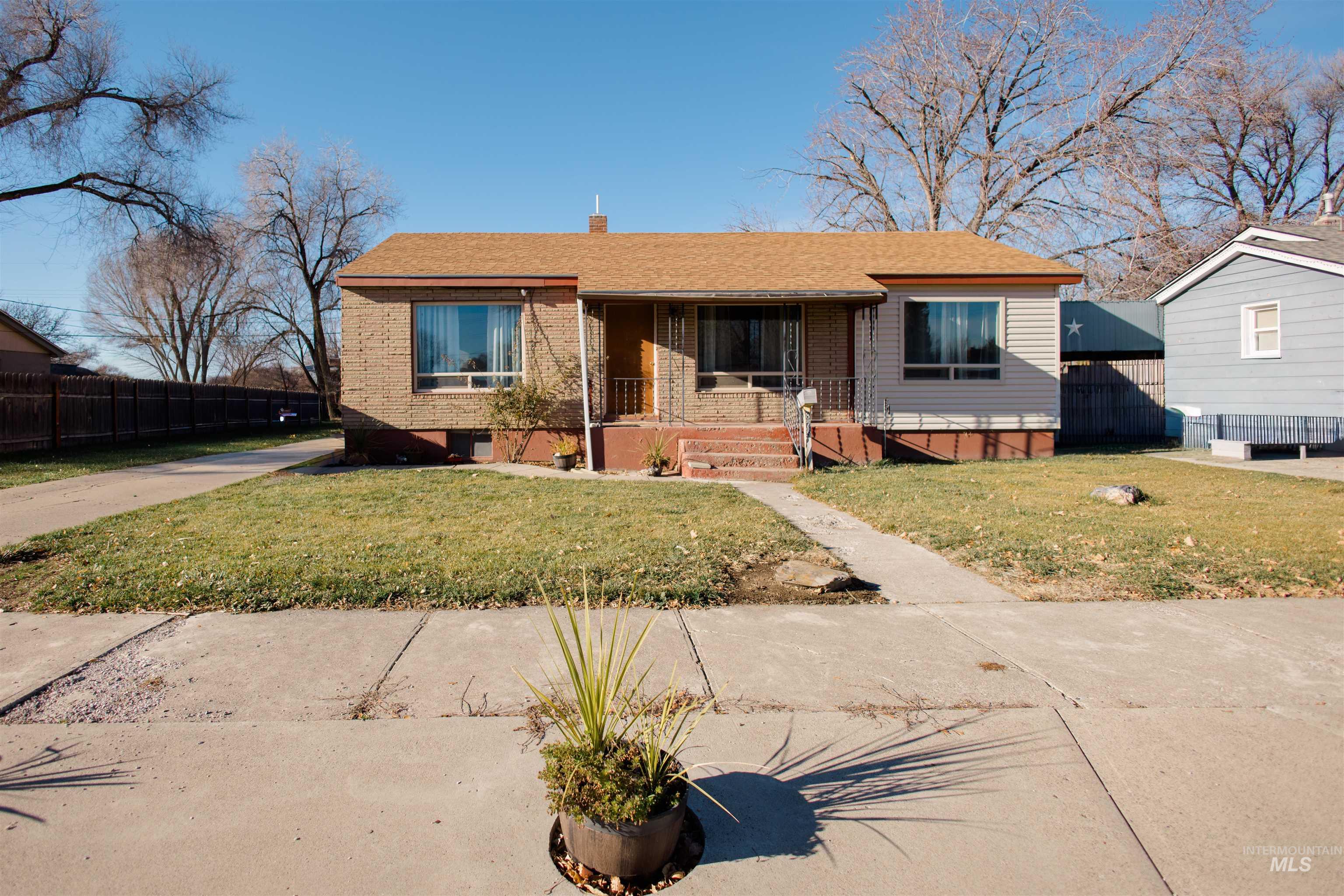 Bungalow featuring a porch, brick siding, a chimney, and roof with shingles