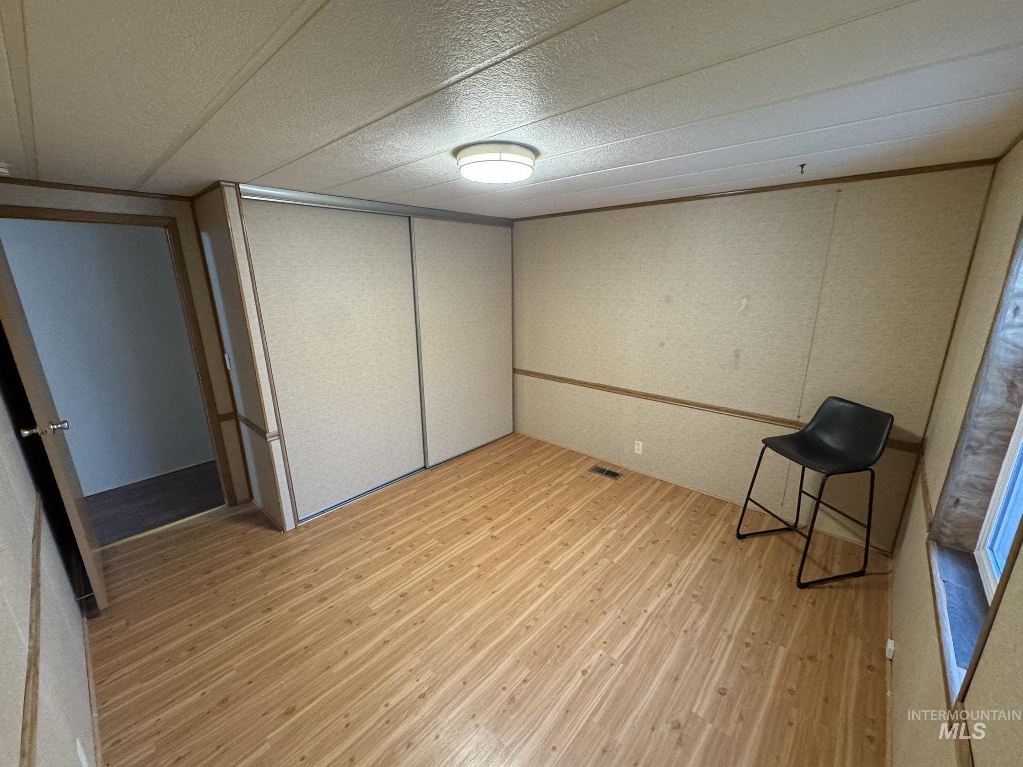 Unfurnished bedroom featuring light wood-style floors and a closet