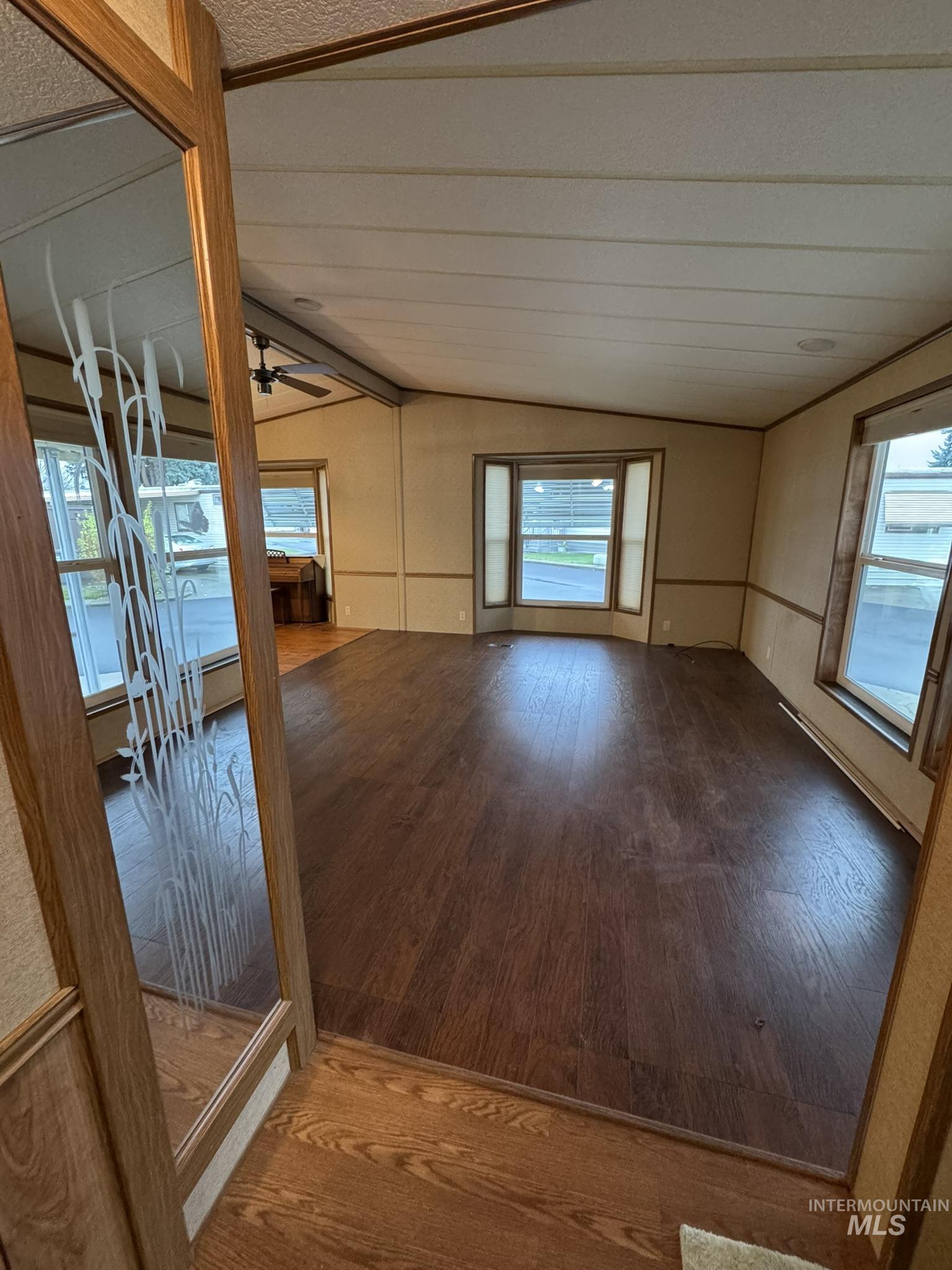 Spare room with vaulted ceiling, hardwood / wood-style flooring, and a ceiling fan
