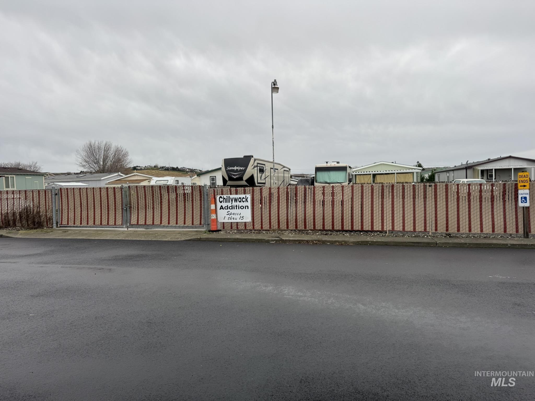 View of asphalt street with street lighting and a gate