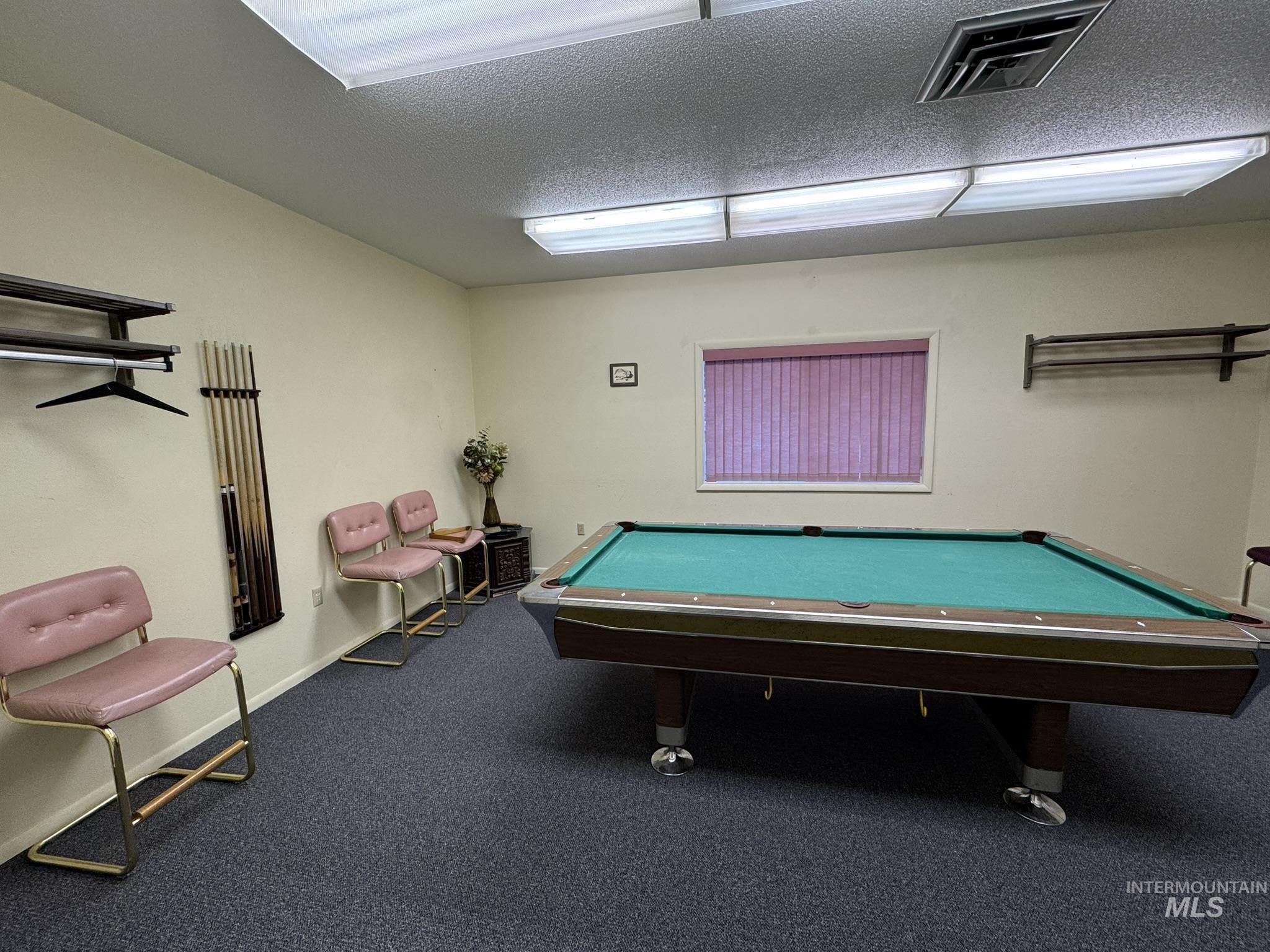 Game room featuring billiards table and a textured ceiling