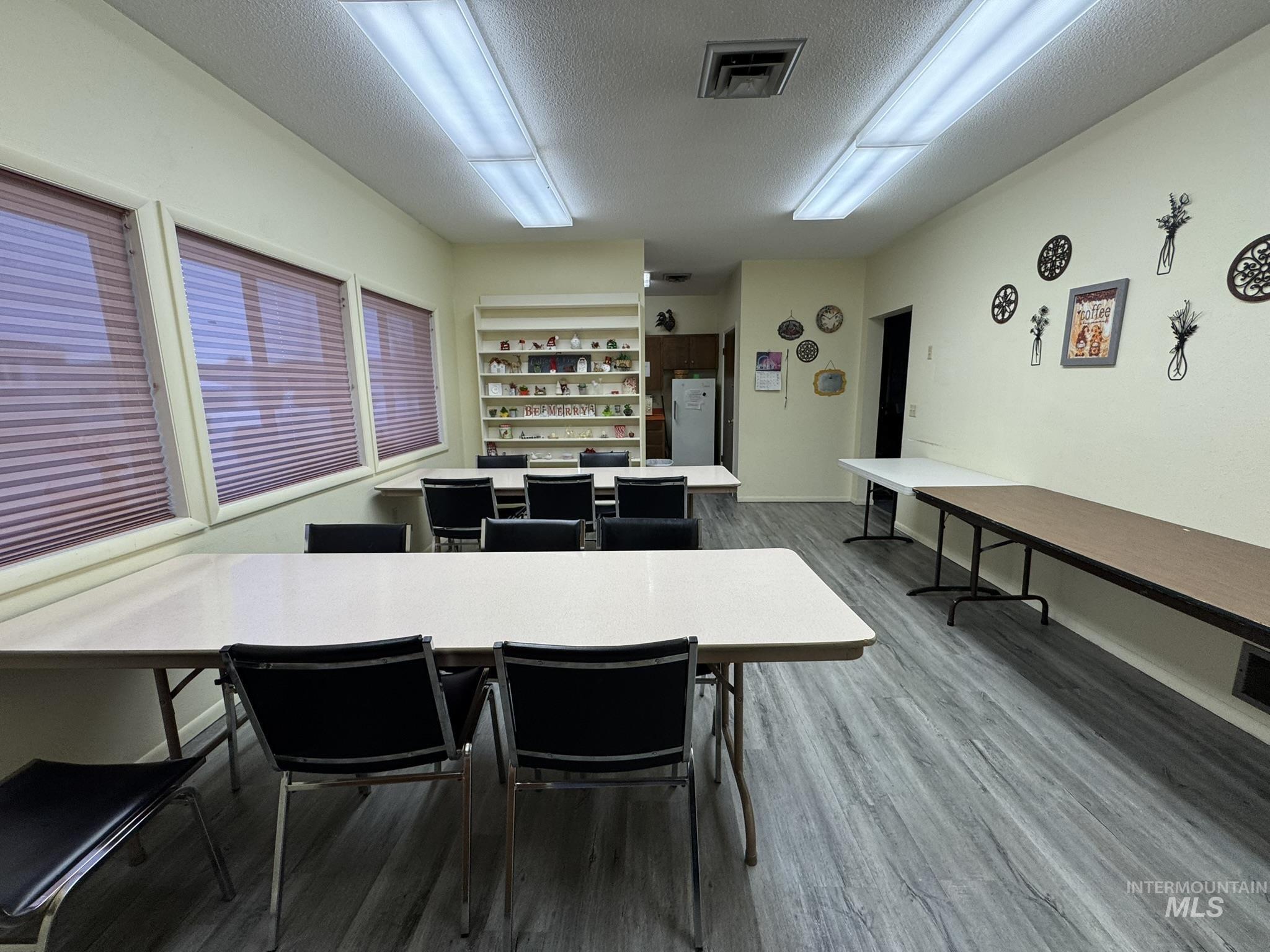 Dining area featuring a textured ceiling and dark wood-style flooring