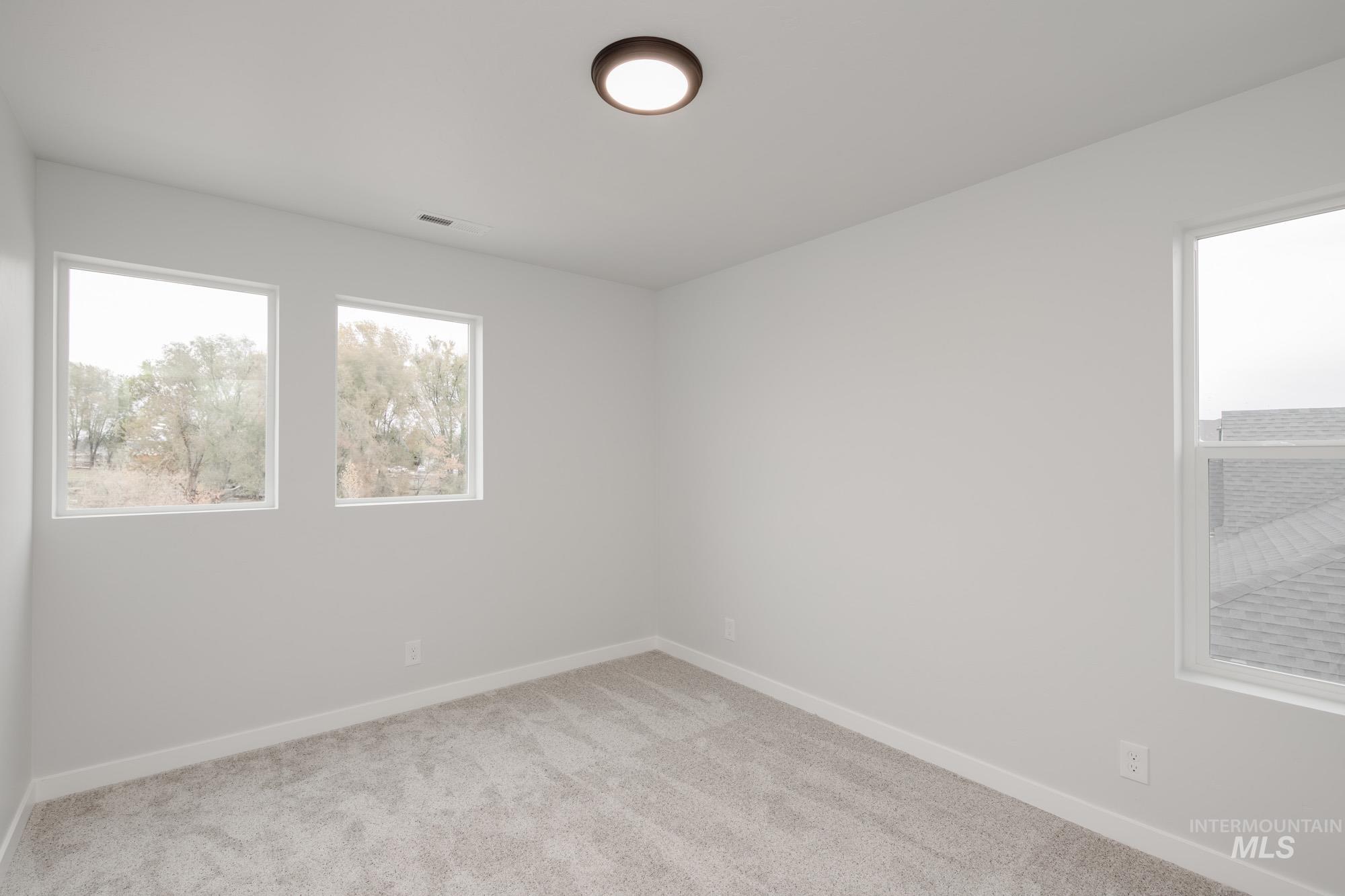 Unfurnished room featuring light colored carpet and baseboards