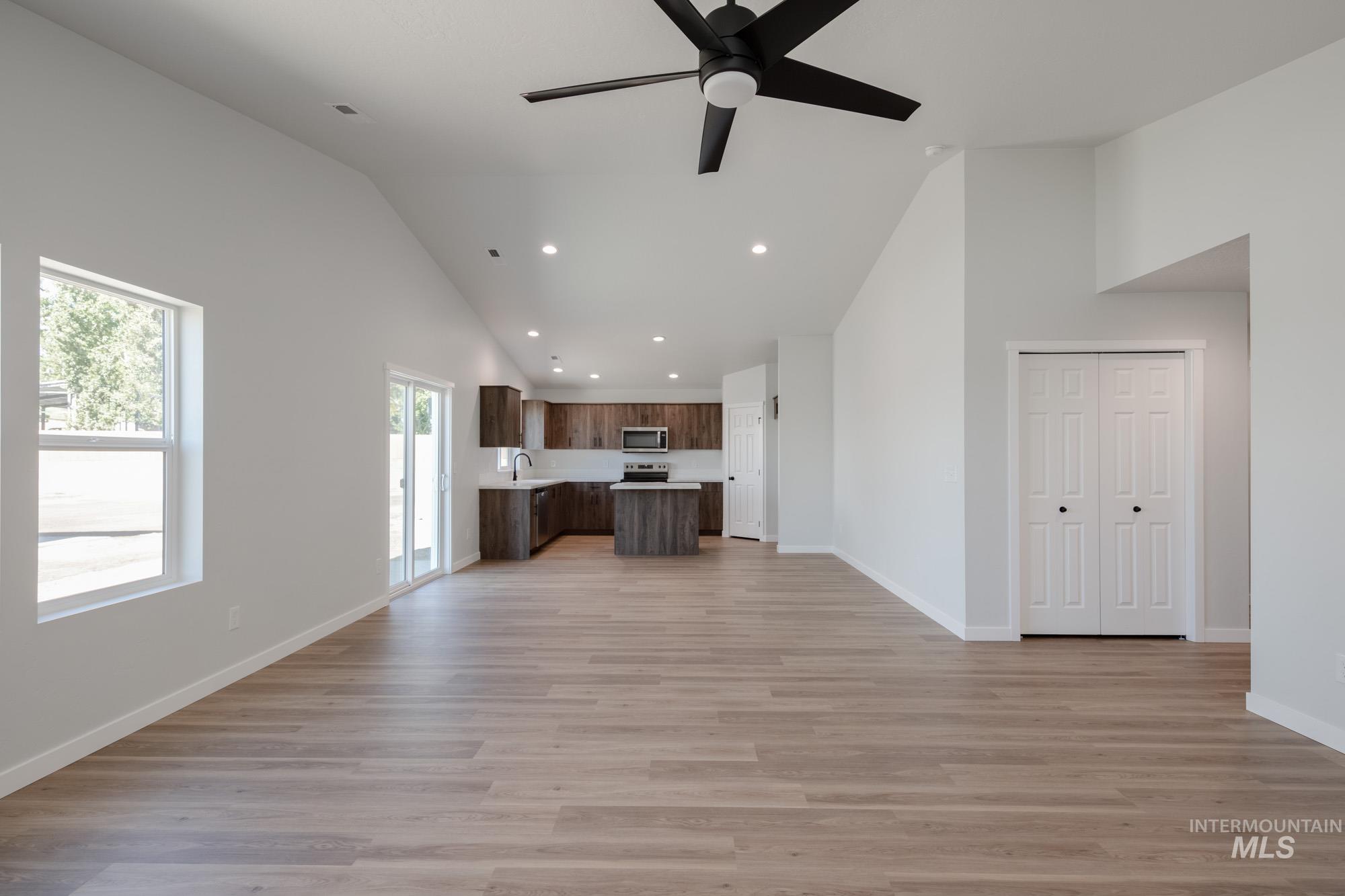 Unfurnished living room with recessed lighting, light wood-type flooring, high vaulted ceiling, and a ceiling fan