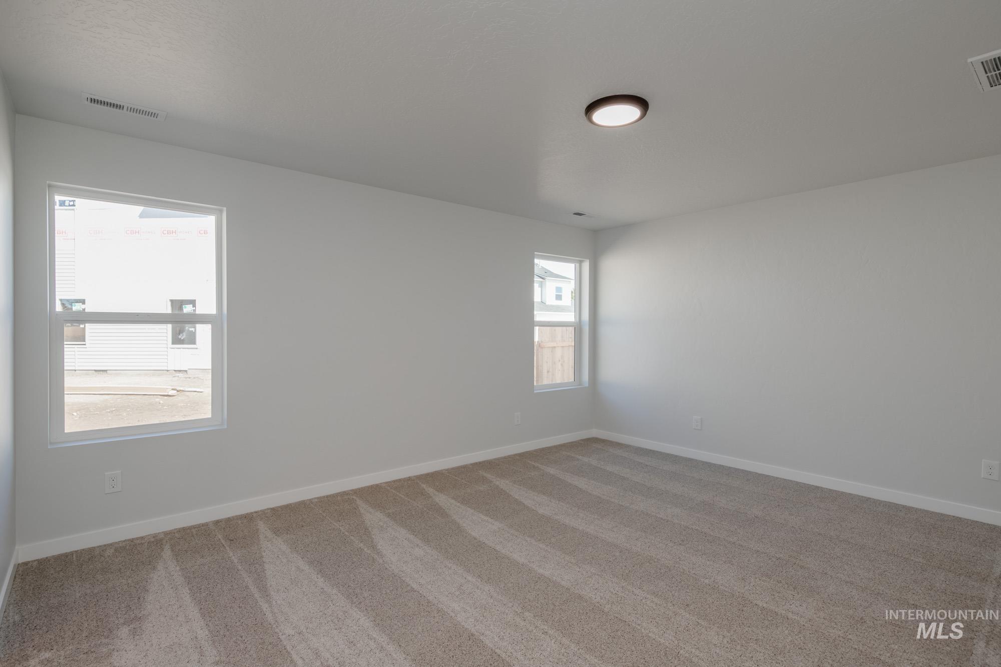 Spare room featuring carpet floors and baseboards