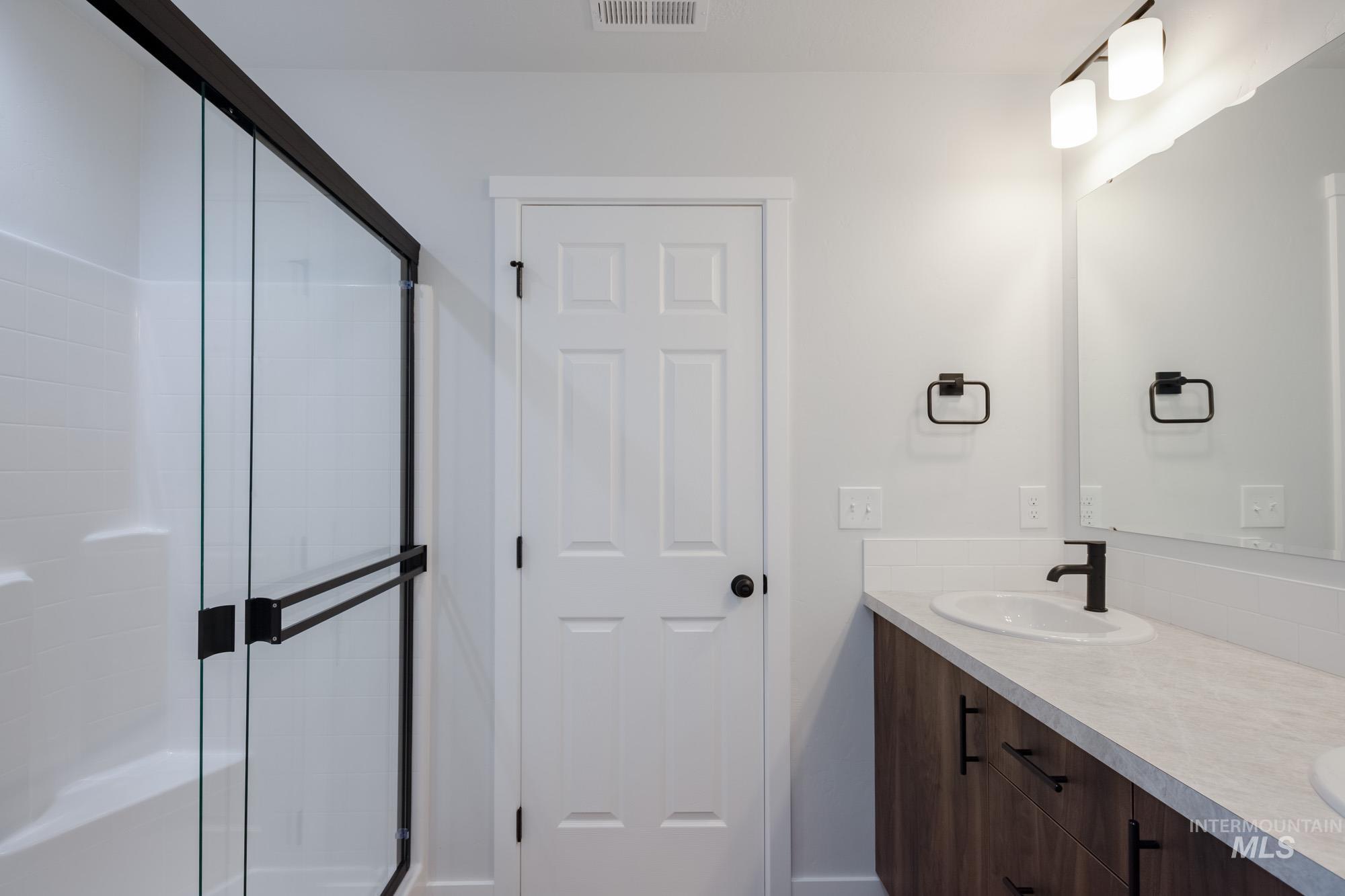 Bathroom with double vanity and a shower stall