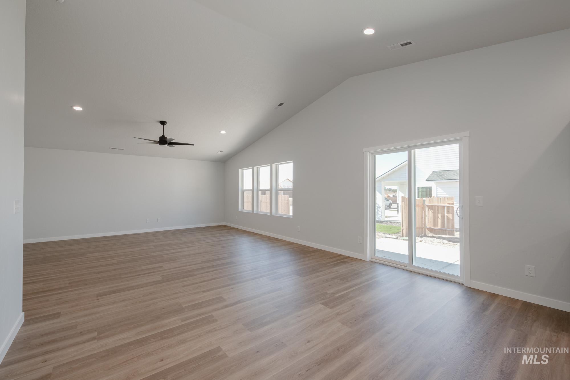 Unfurnished room featuring recessed lighting, light wood-style flooring, a ceiling fan, and high vaulted ceiling