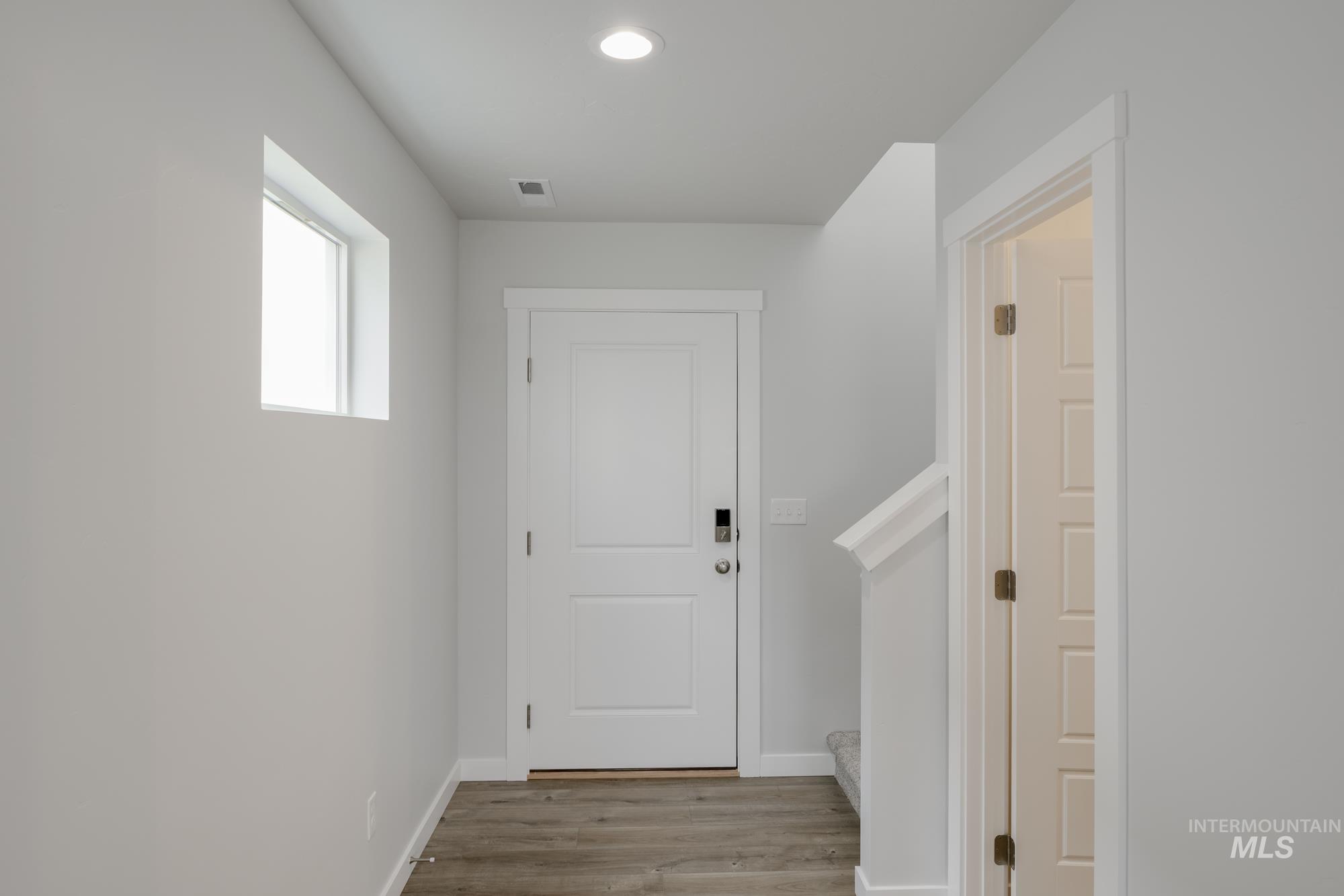 Doorway featuring wood finished floors and recessed lighting