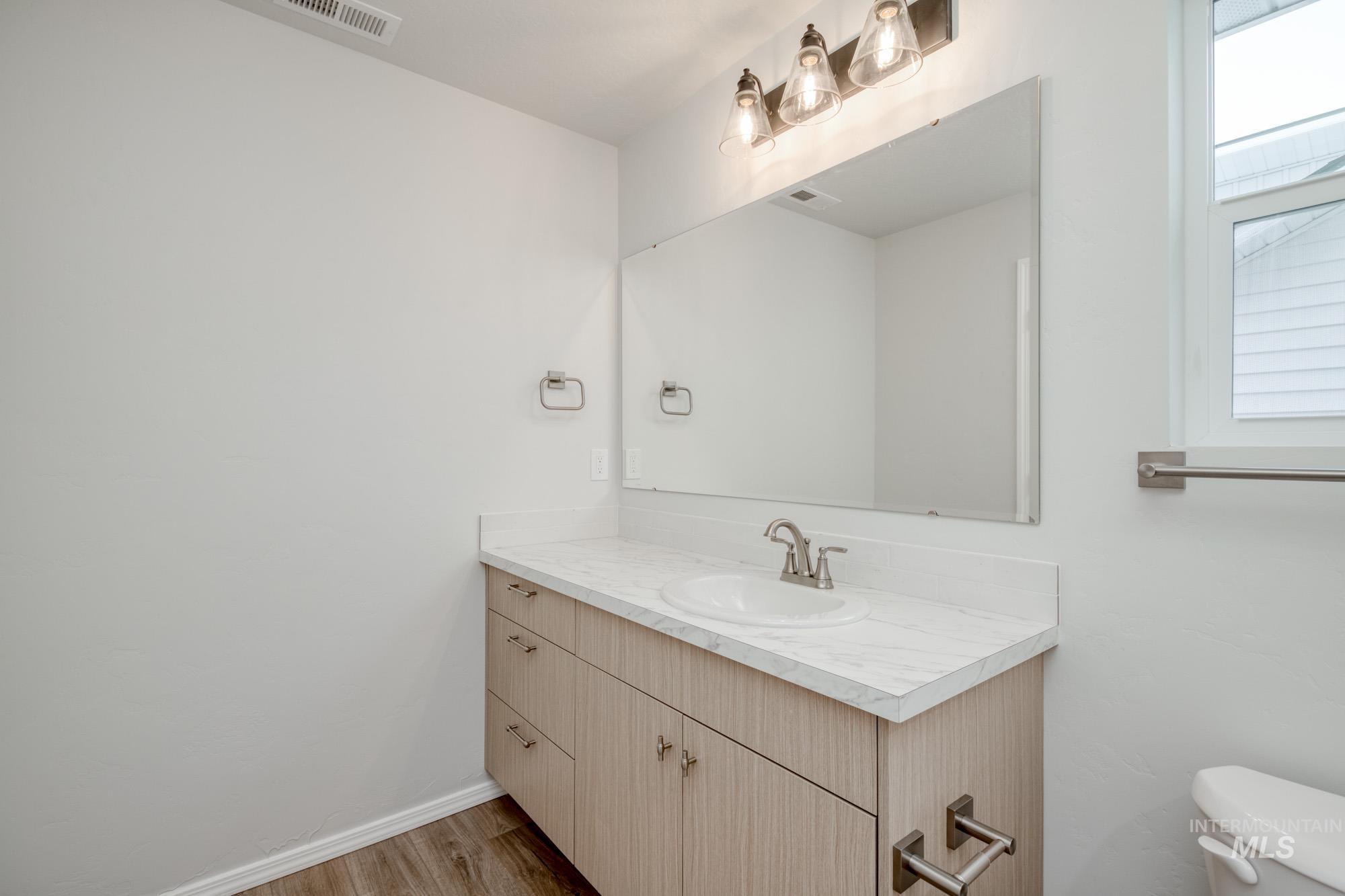 Half bath featuring vanity and light wood finished floors