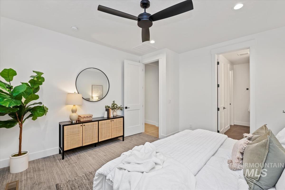 Carpeted bedroom with recessed lighting and ceiling fan
