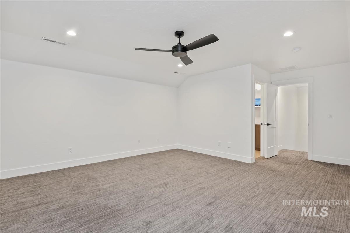 Unfurnished room featuring light carpet, recessed lighting, ceiling fan, and vaulted ceiling