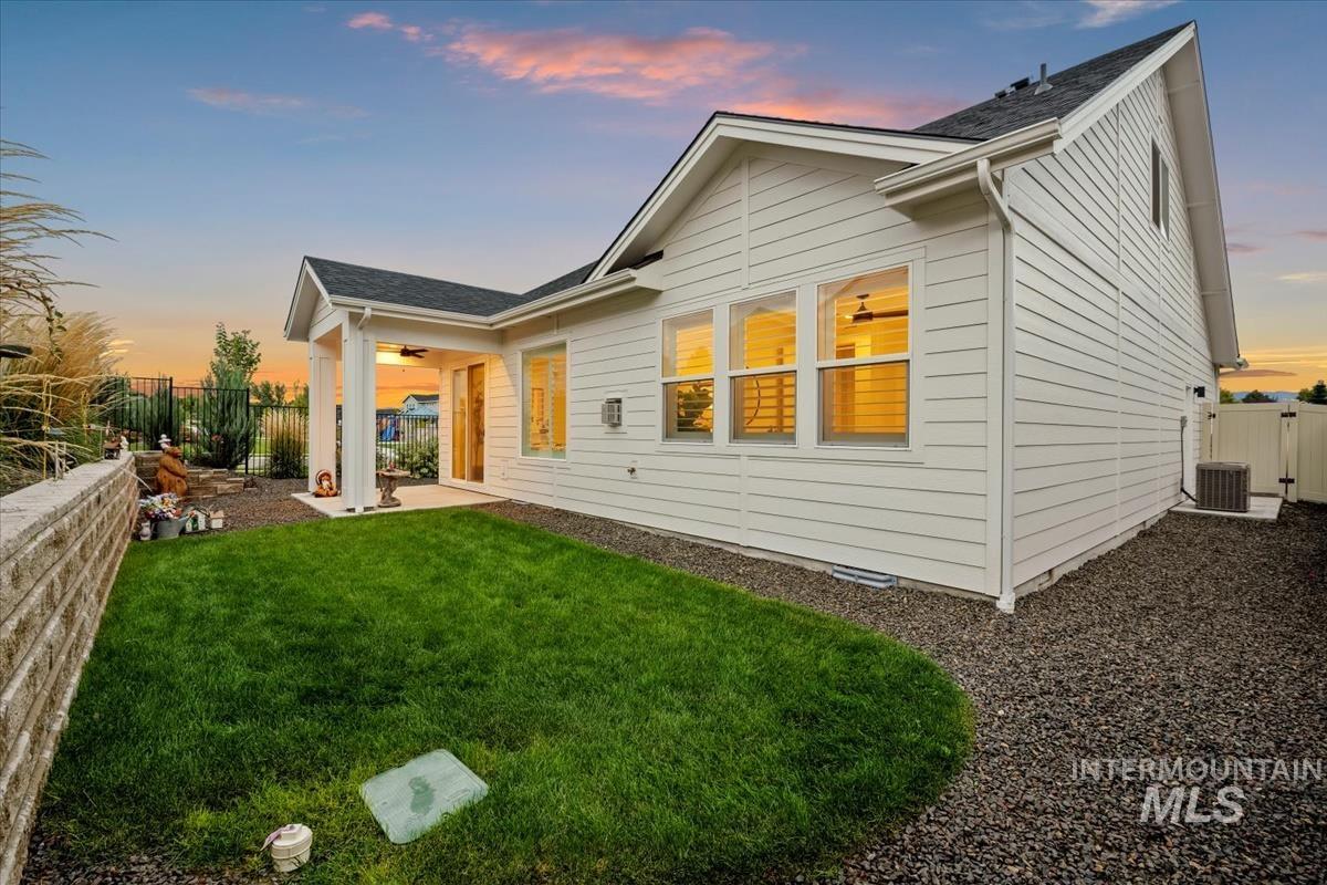Back of property at dusk with a patio and a ceiling fan