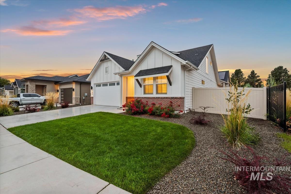 Modern farmhouse style home with board and batten siding, concrete driveway, brick siding, and a shingled roof