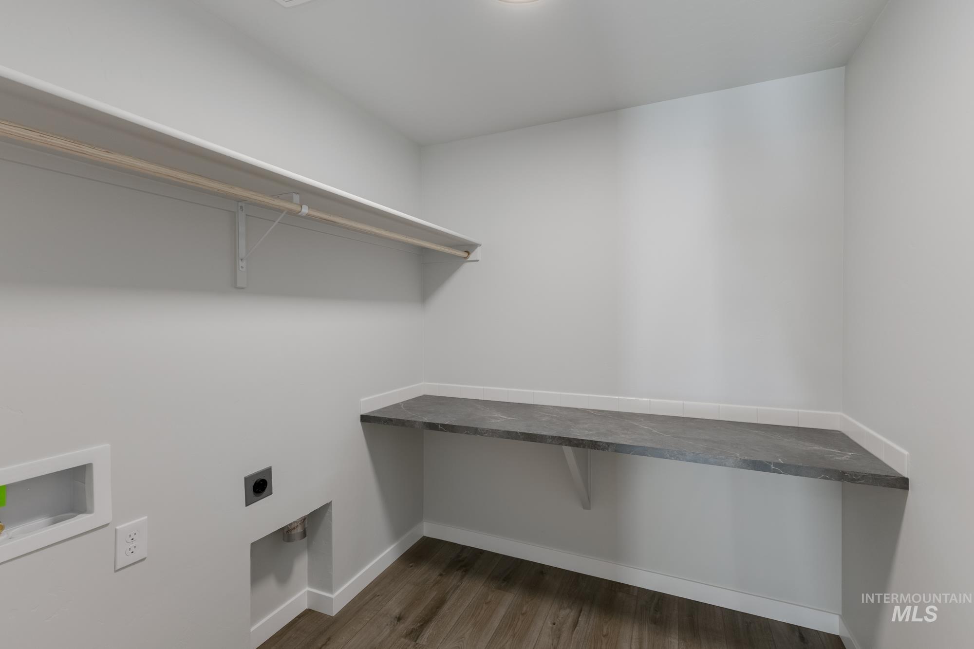 Laundry area with dark wood finished floors, hookup for an electric dryer, and washer hookup