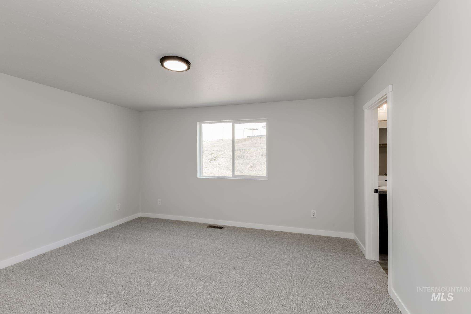 Empty room featuring light colored carpet