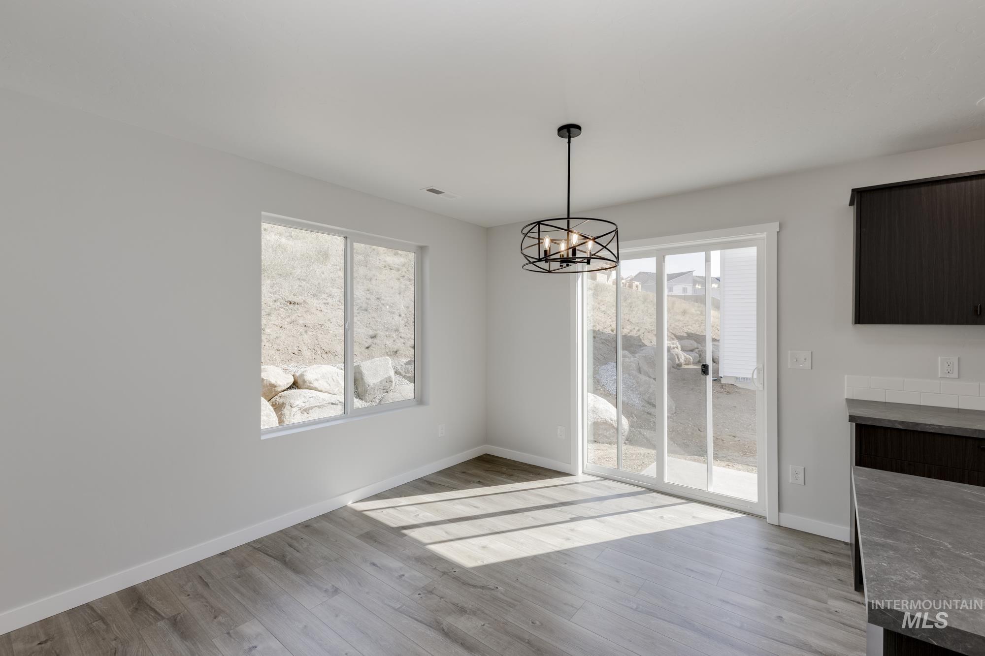 Unfurnished dining area with a chandelier and light wood-style floors