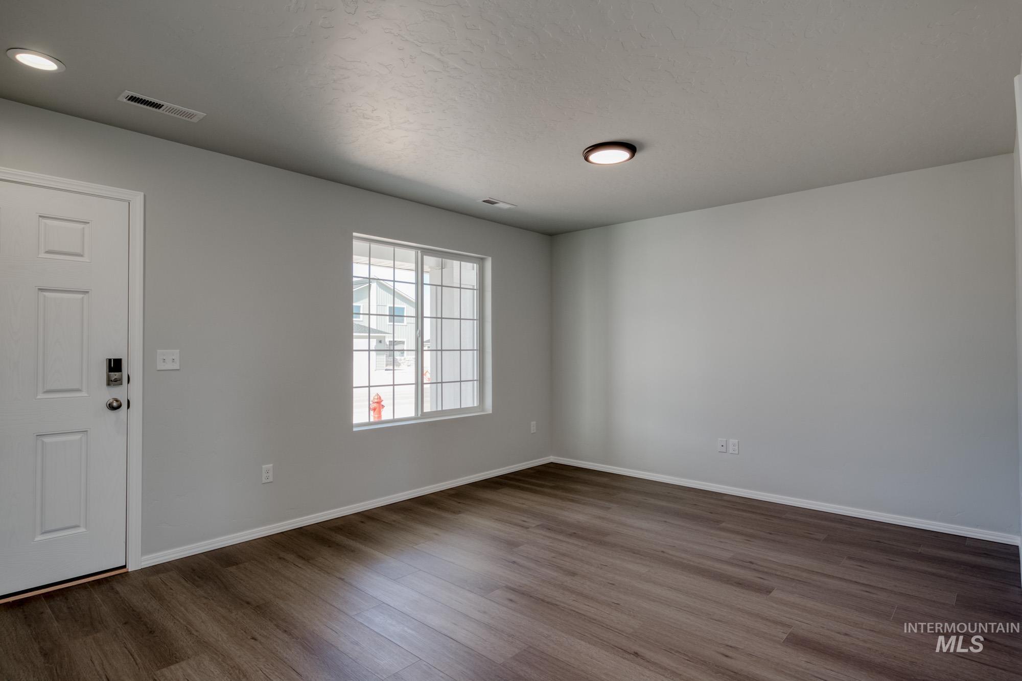 Foyer entrance featuring dark wood-style floors and a textured ceiling