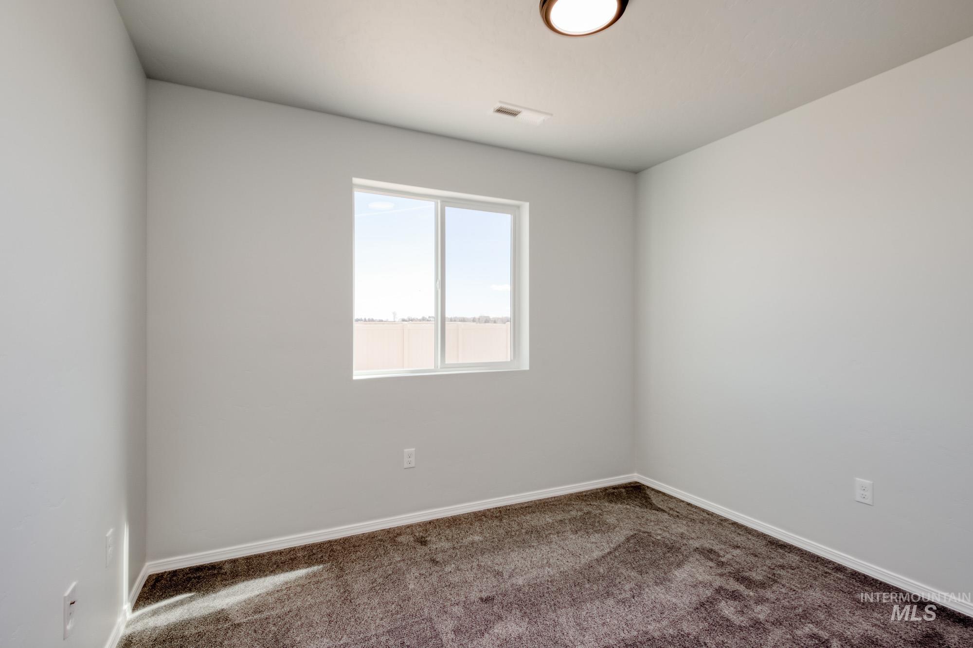 Spare room with carpet and baseboards