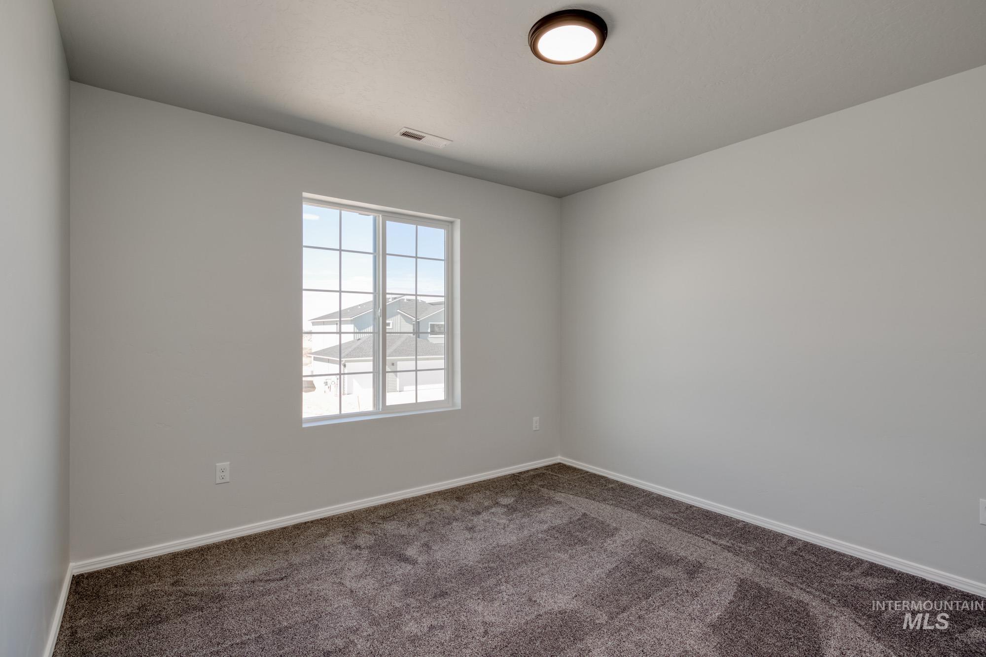 Carpeted spare room with baseboards
