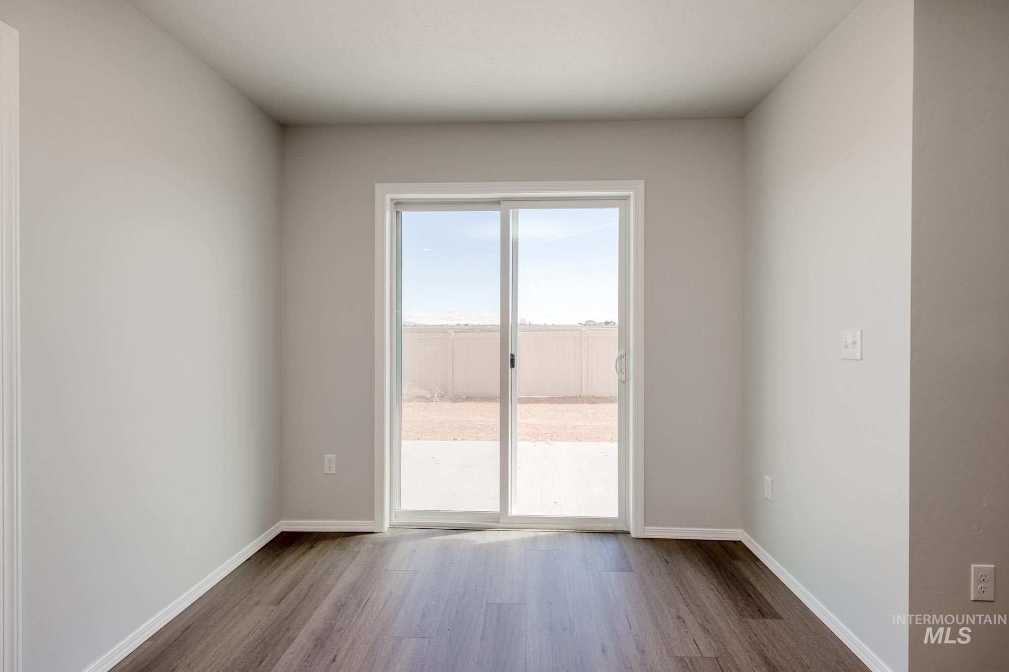 Unfurnished room with wood finished floors and baseboards
